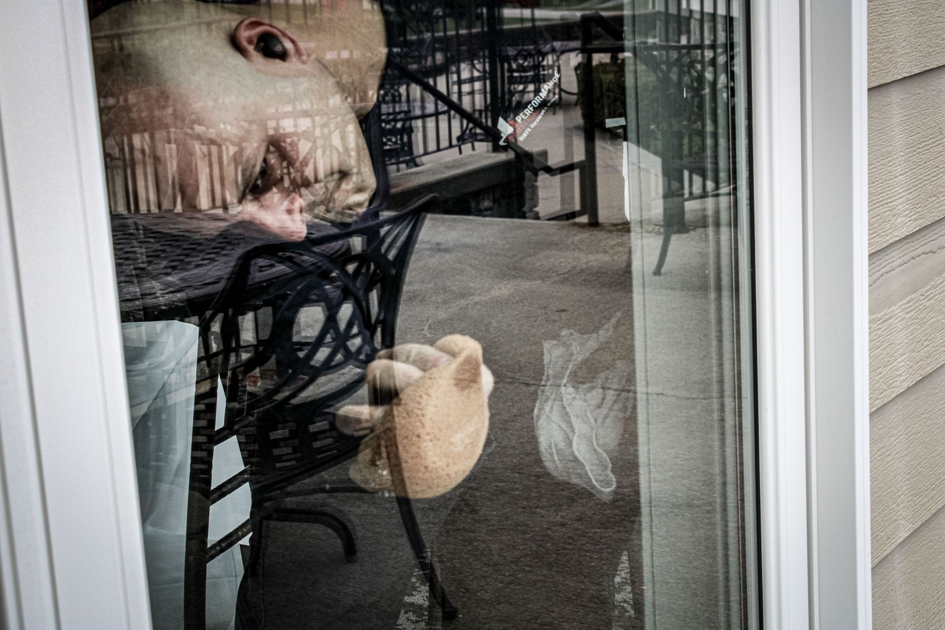 A person is sitting at a table looking out of a window.