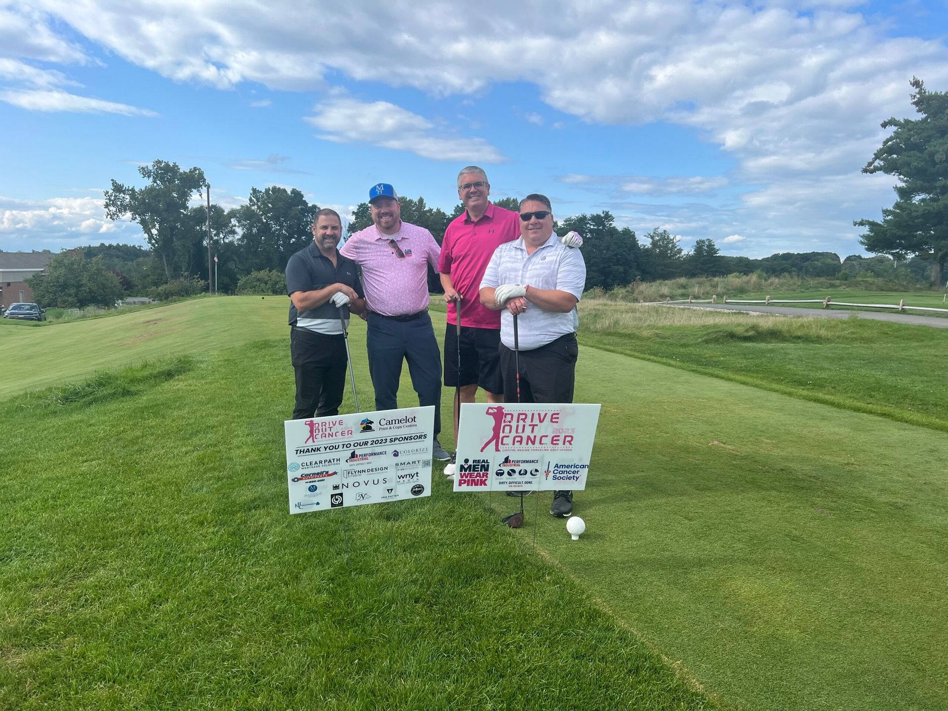 A group of men are posing for a picture on a golf course.