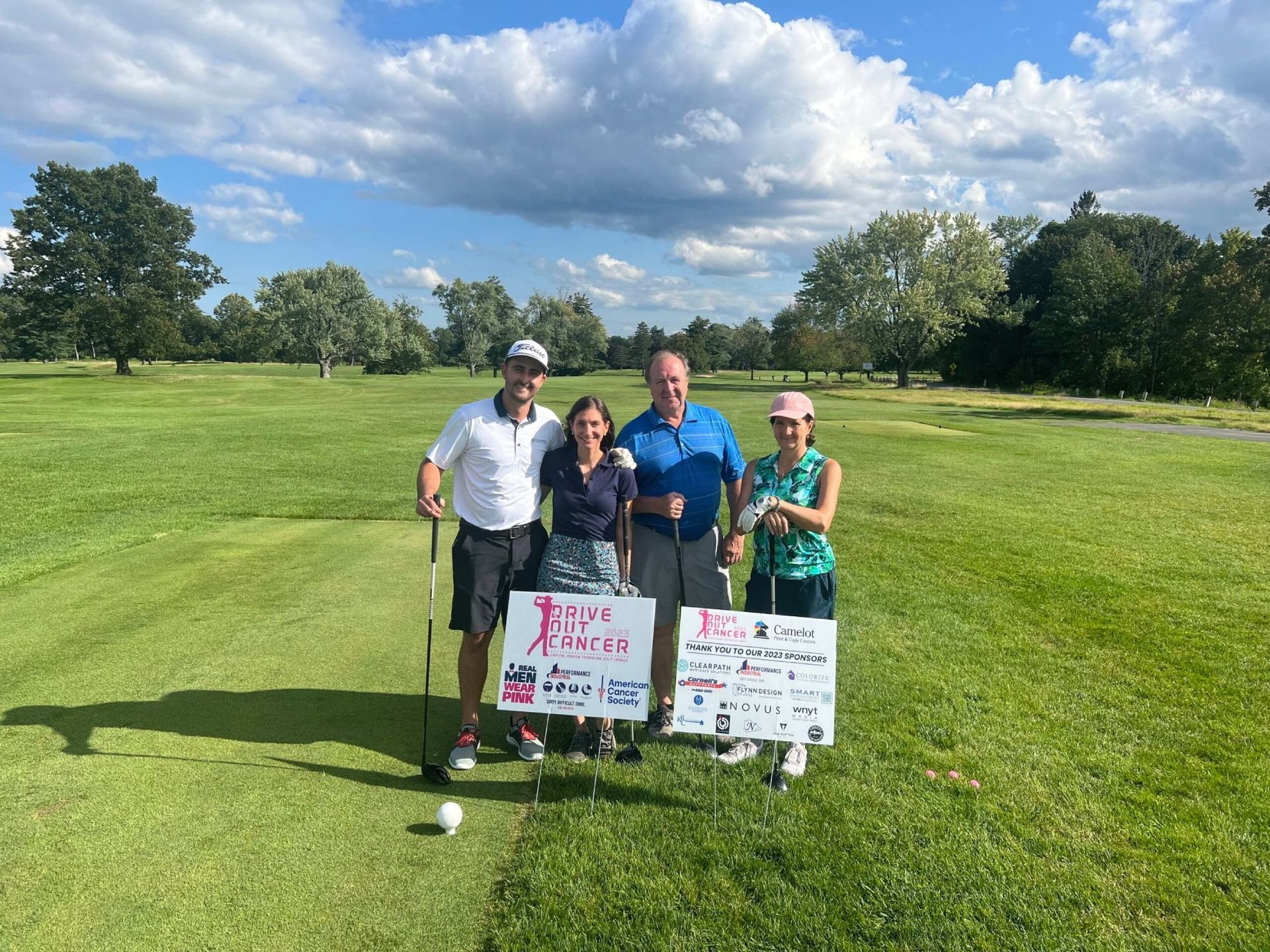 A group of people are posing for a picture on a golf course.