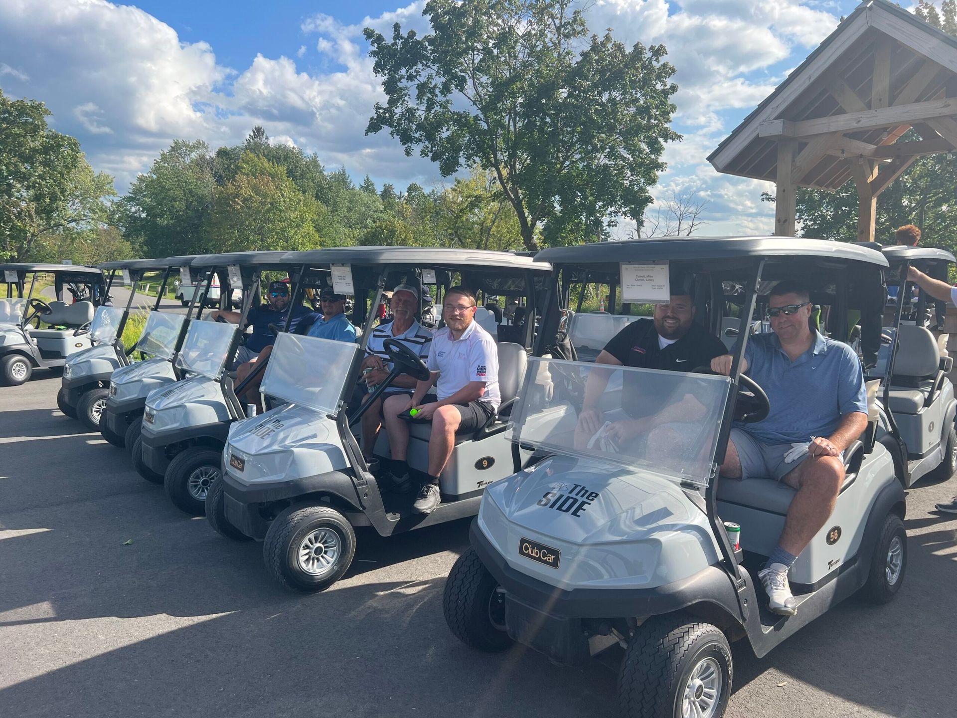 A group of people are sitting in golf carts on a golf course.