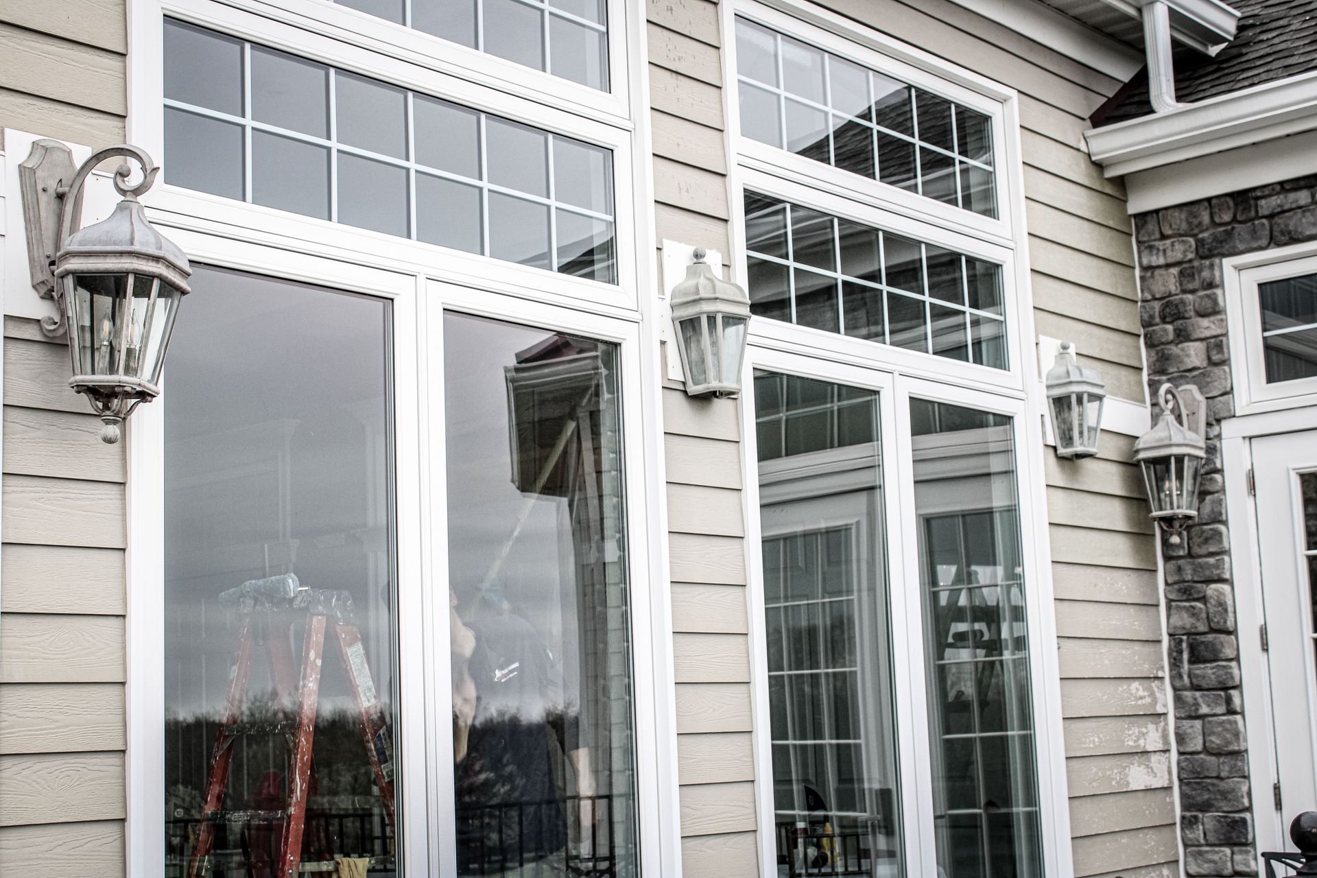 A house with a lot of windows and lanterns on the side of it.