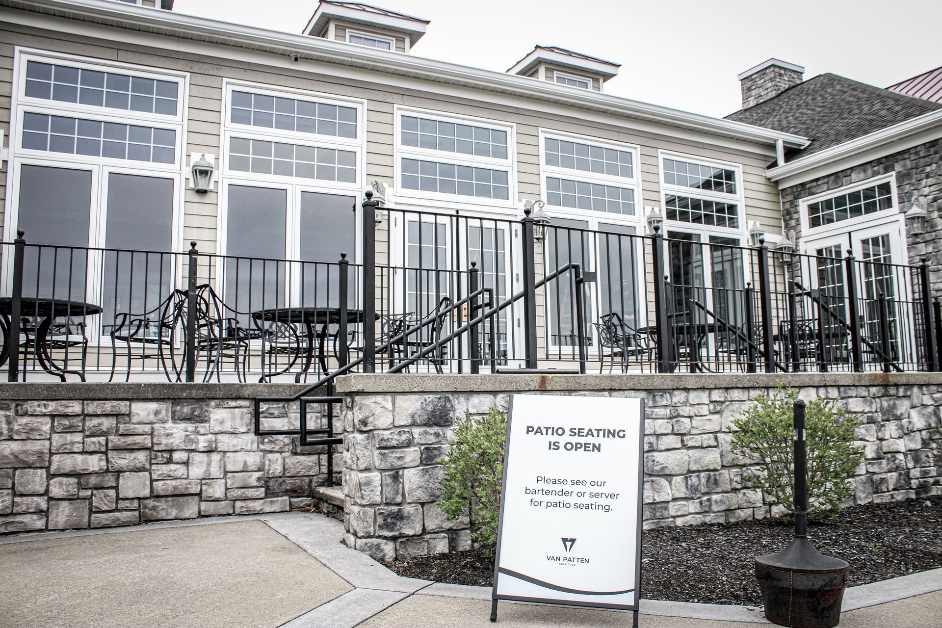 A large building with tables and chairs in front of it.