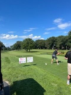 A man is swinging a golf club on a golf course.