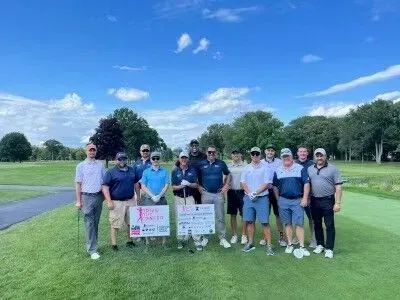 A group of people are posing for a picture on a golf course.