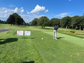 A man is swinging a golf club on a golf course.