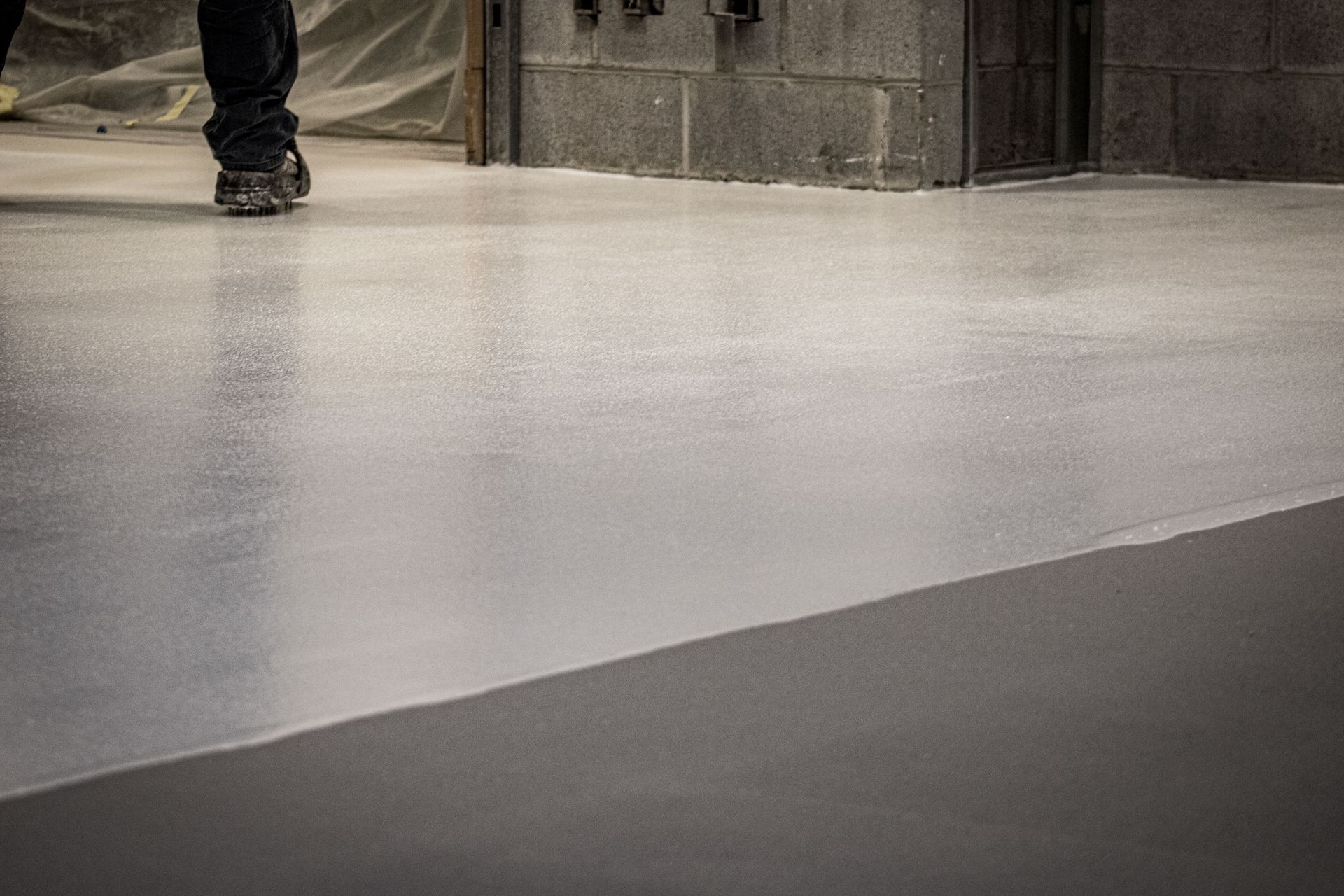A person is walking on a concrete floor.