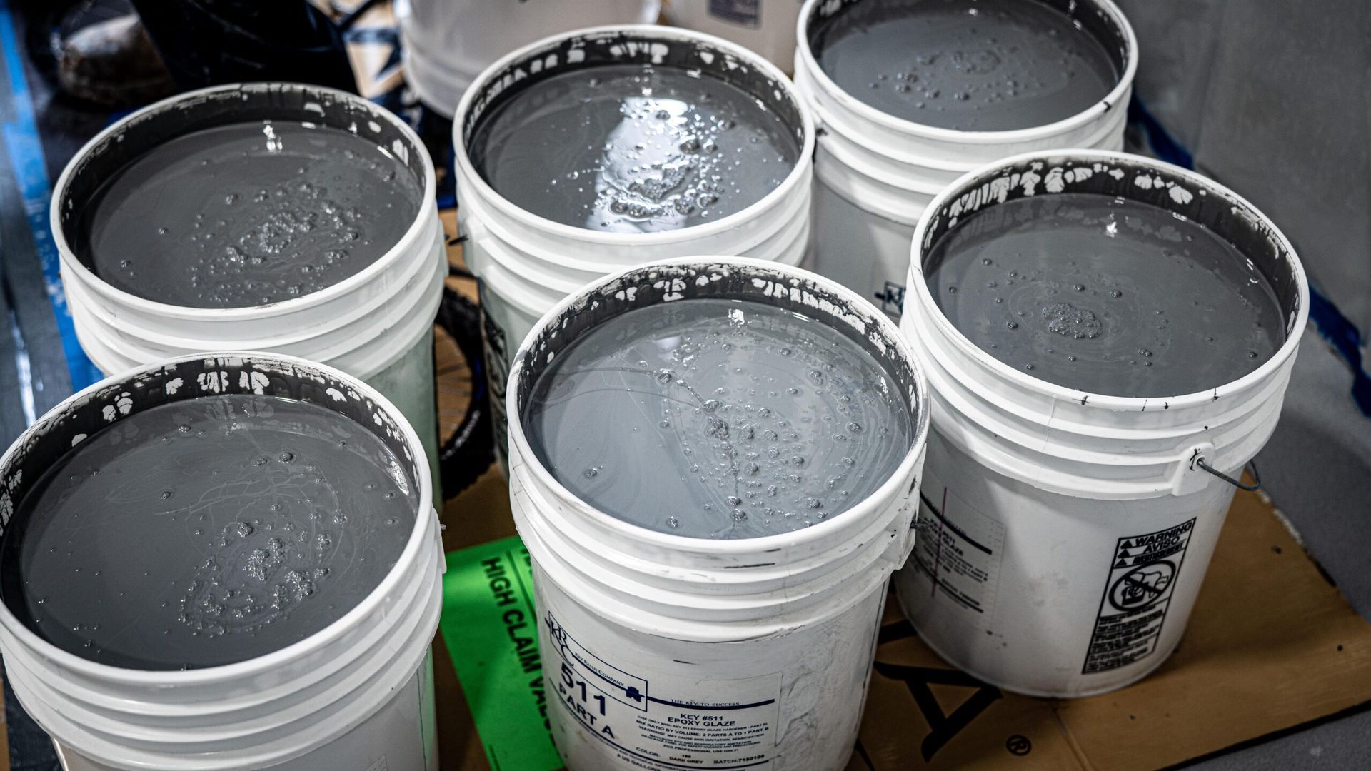 A group of buckets filled with liquid are sitting on top of each other on a table.