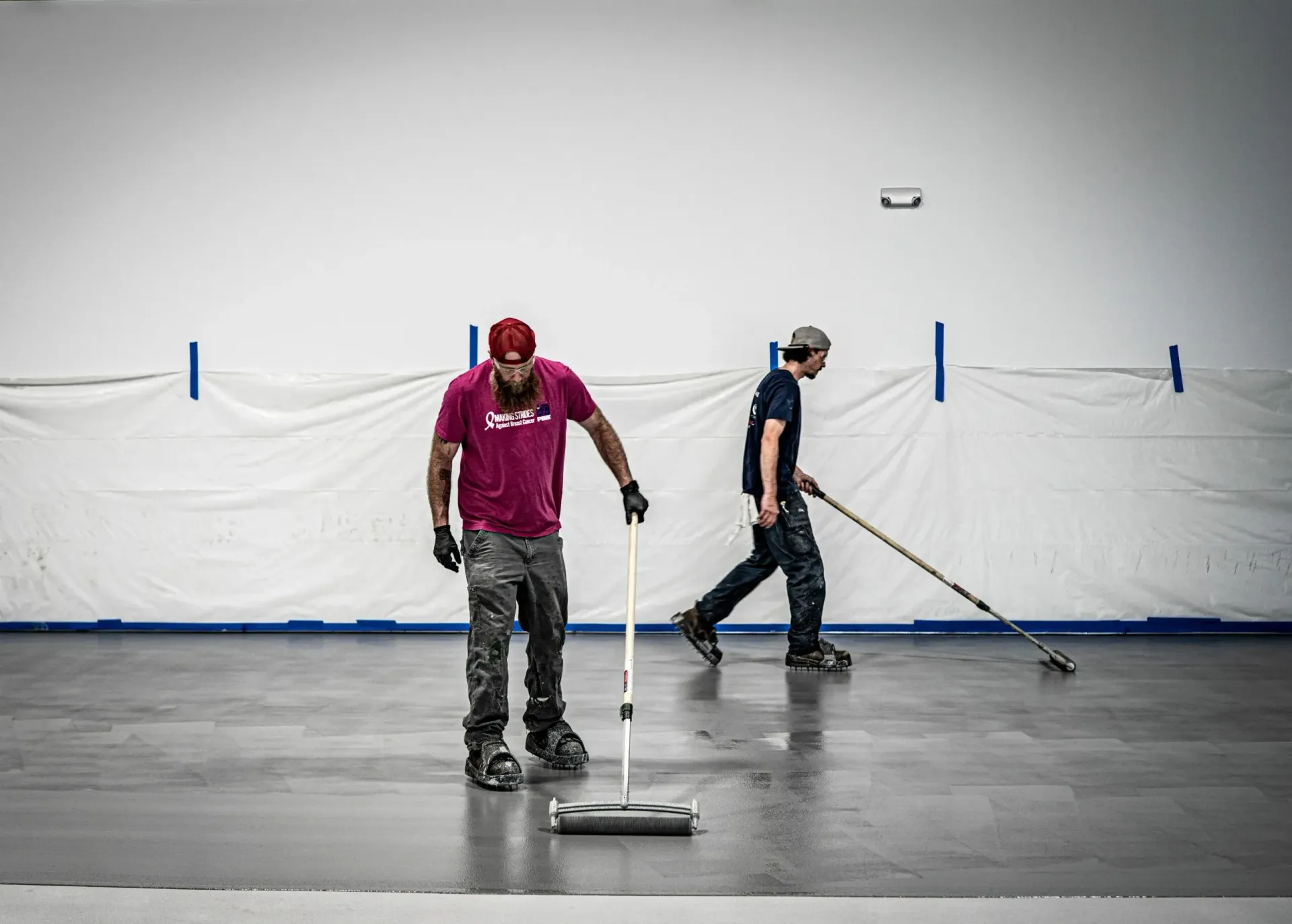 Two Men Are Cleaning a Concrete Floor with Brooms | S. Glens Falls, NY | Performance Industrial