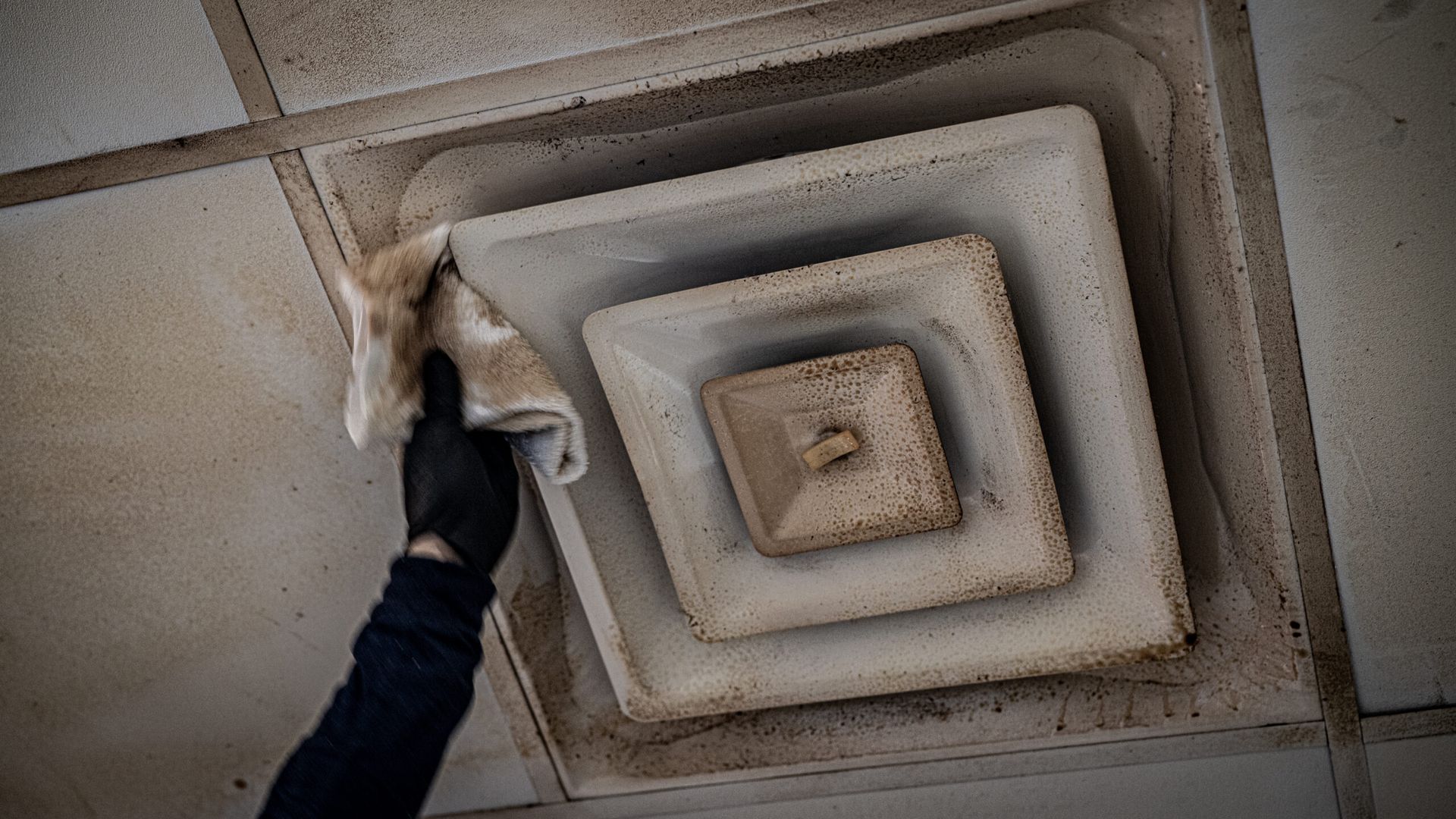 A Person Is Cleaning a Ceiling Vent with A Cloth | S. Glens Falls, NY | Performance Industrial