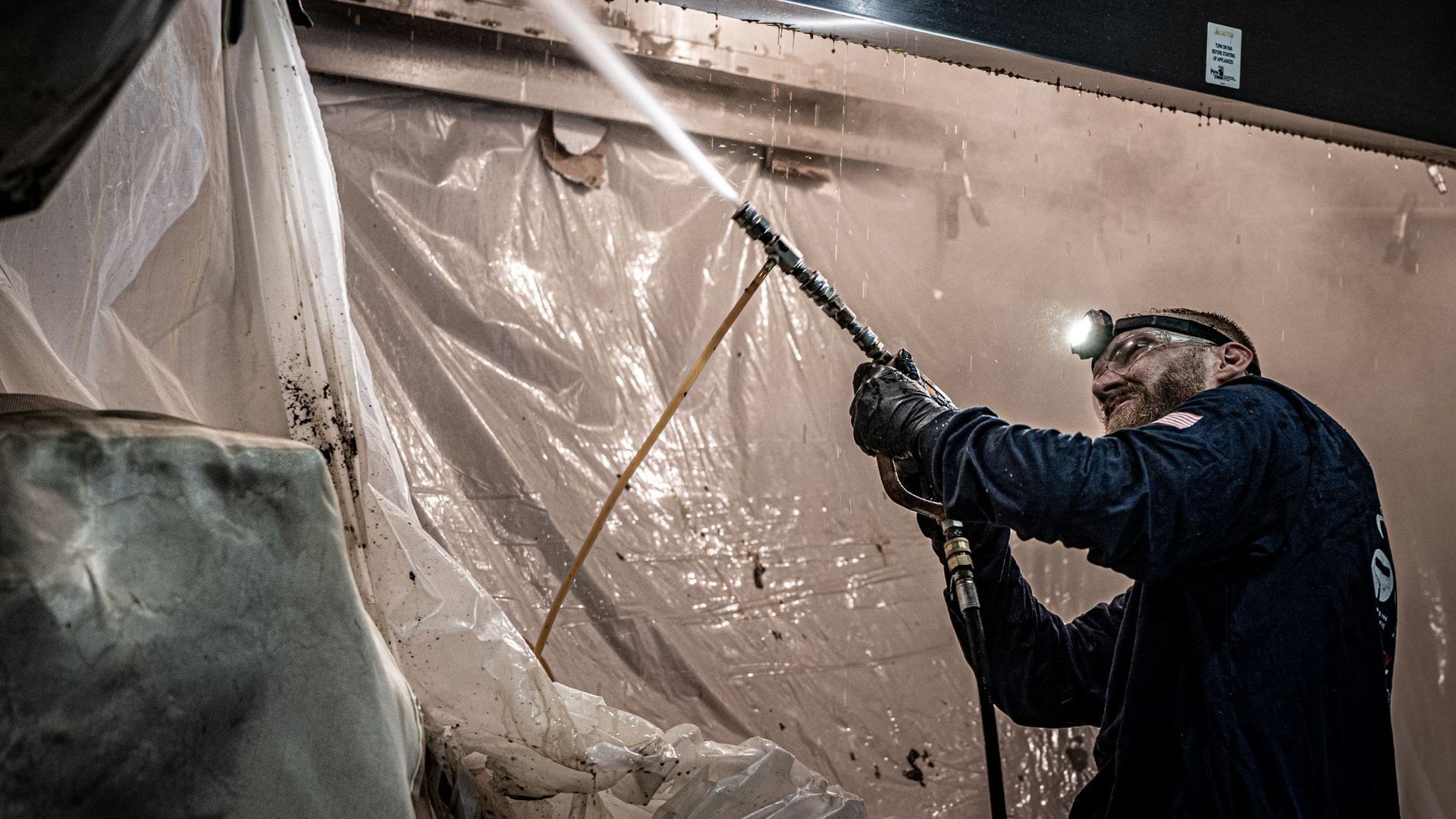 A Man Is Spraying a Wall with A High Pressure Washer | S. Glens Falls, NY | Performance Industrial
