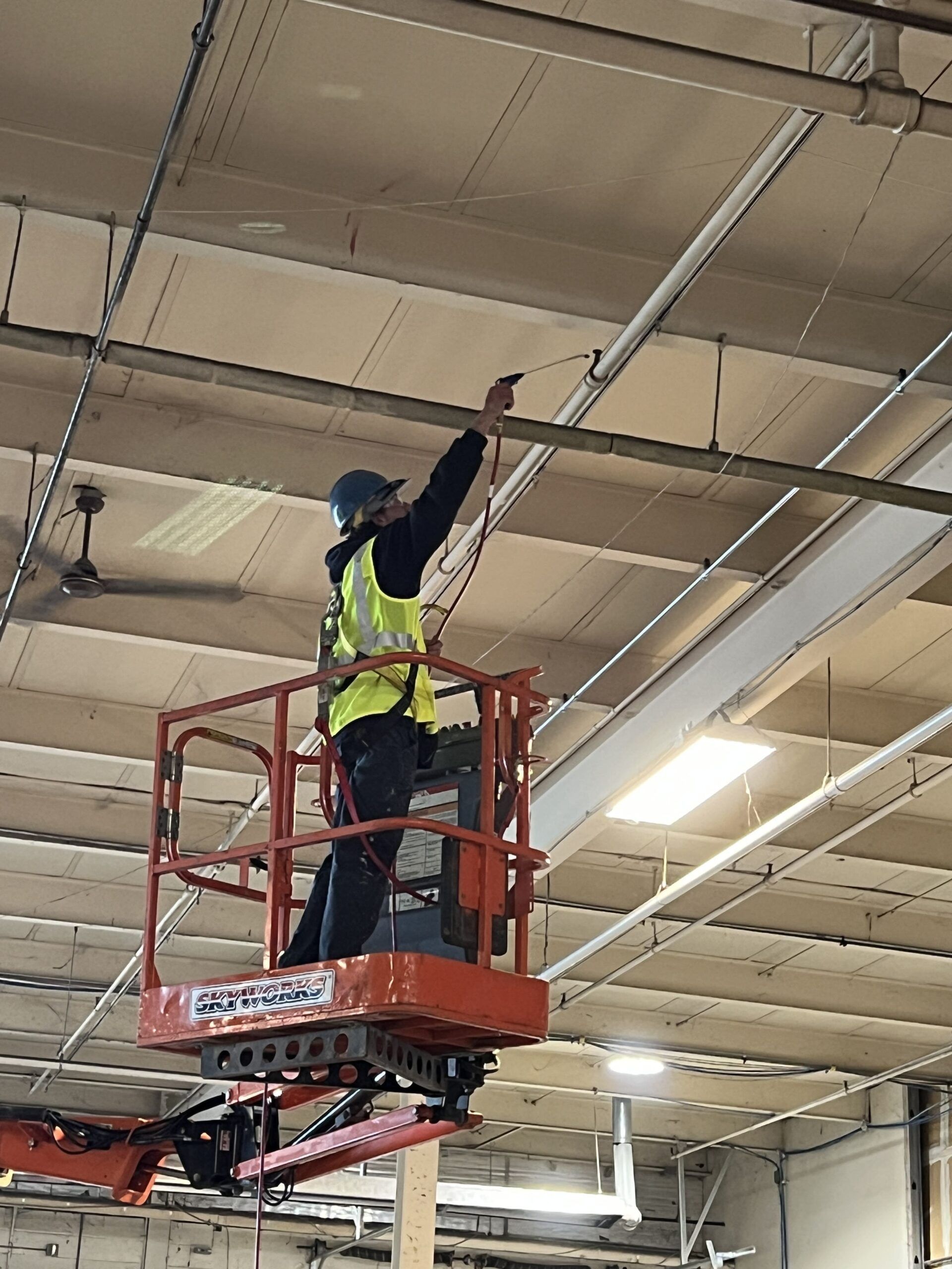 A Man Is Standing on A Lift Working on A Ceiling | S. Glens Falls, NY | Performance Industrial