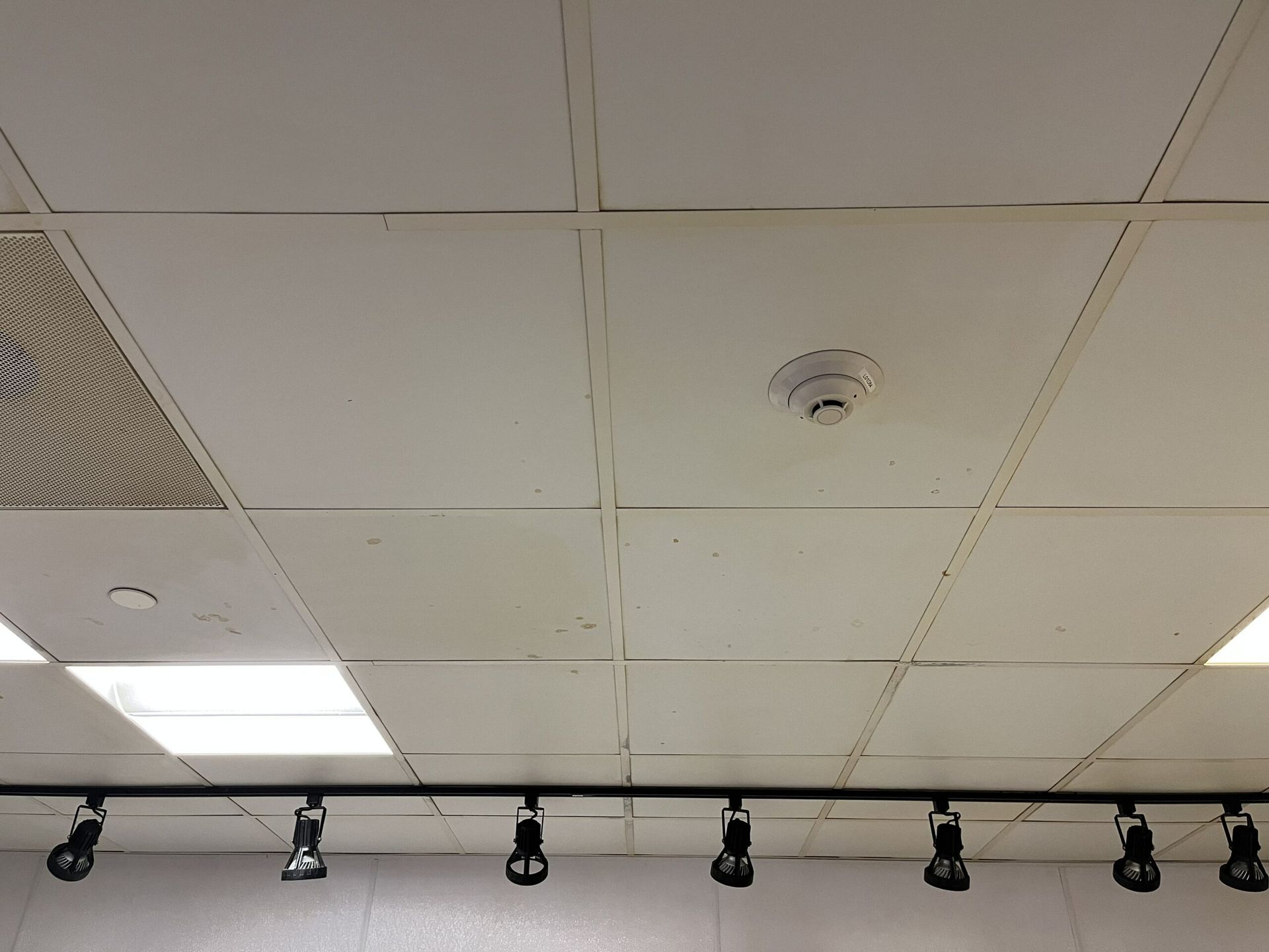 A ceiling with a smoke detector on it