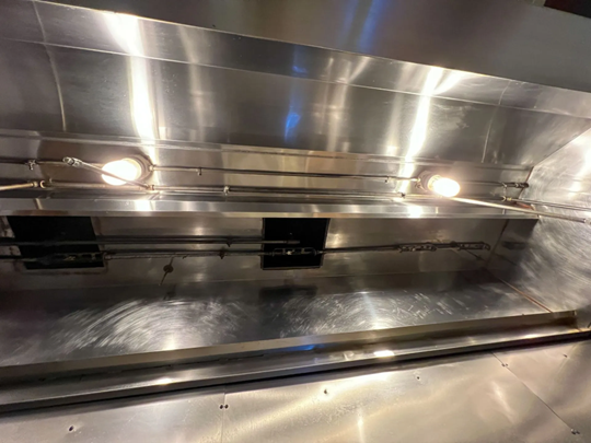 Professional kitchen exhaust cleaning in Saratoga Springs, NY, showing a thoroughly cleaned stainless steel commercial range hood interior.