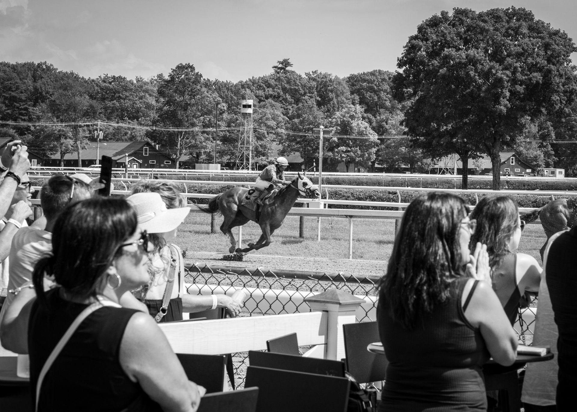 A black and white photo of people watching a horse race
