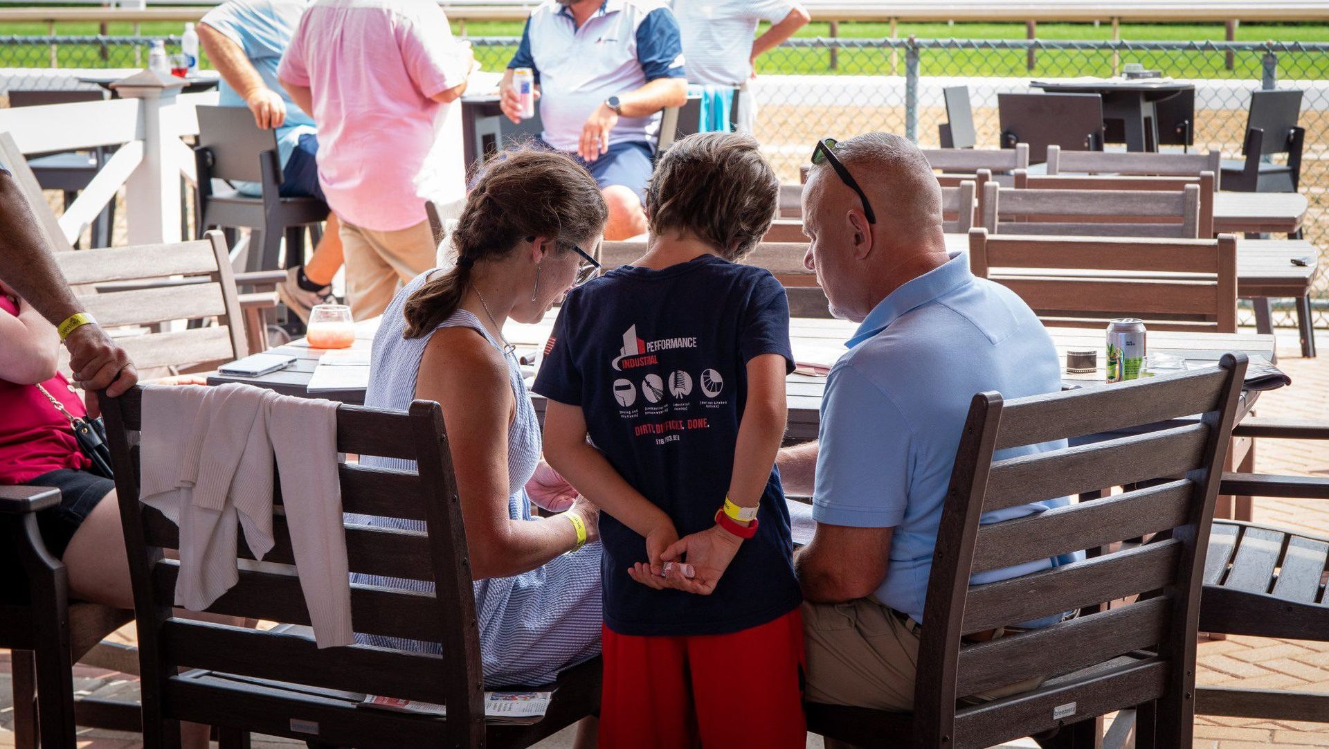 A group of people are sitting on a wooden bench.
