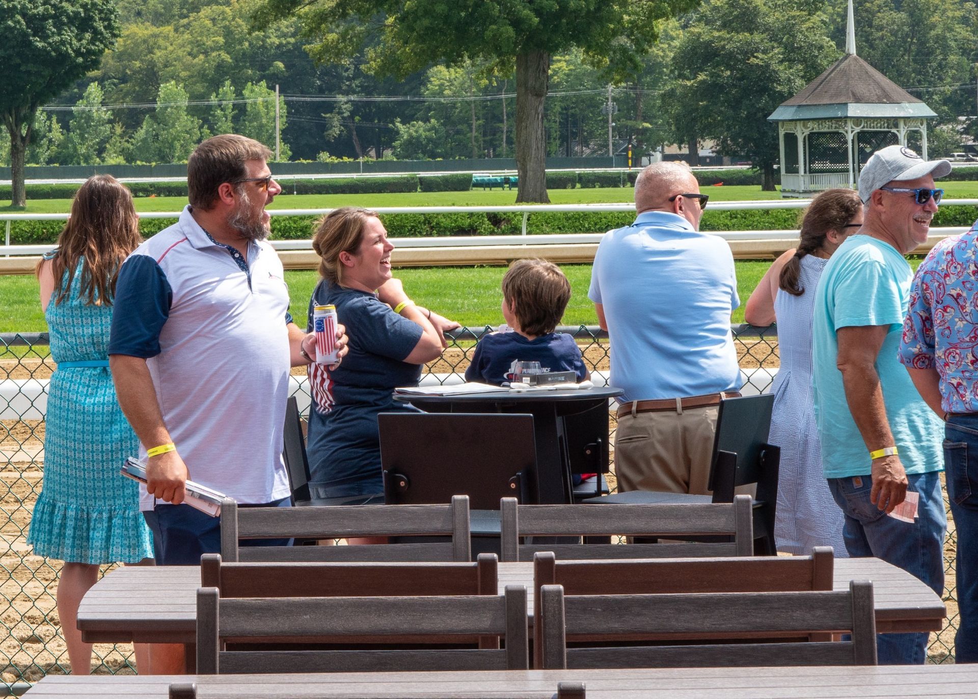A group of people sitting at tables in a park