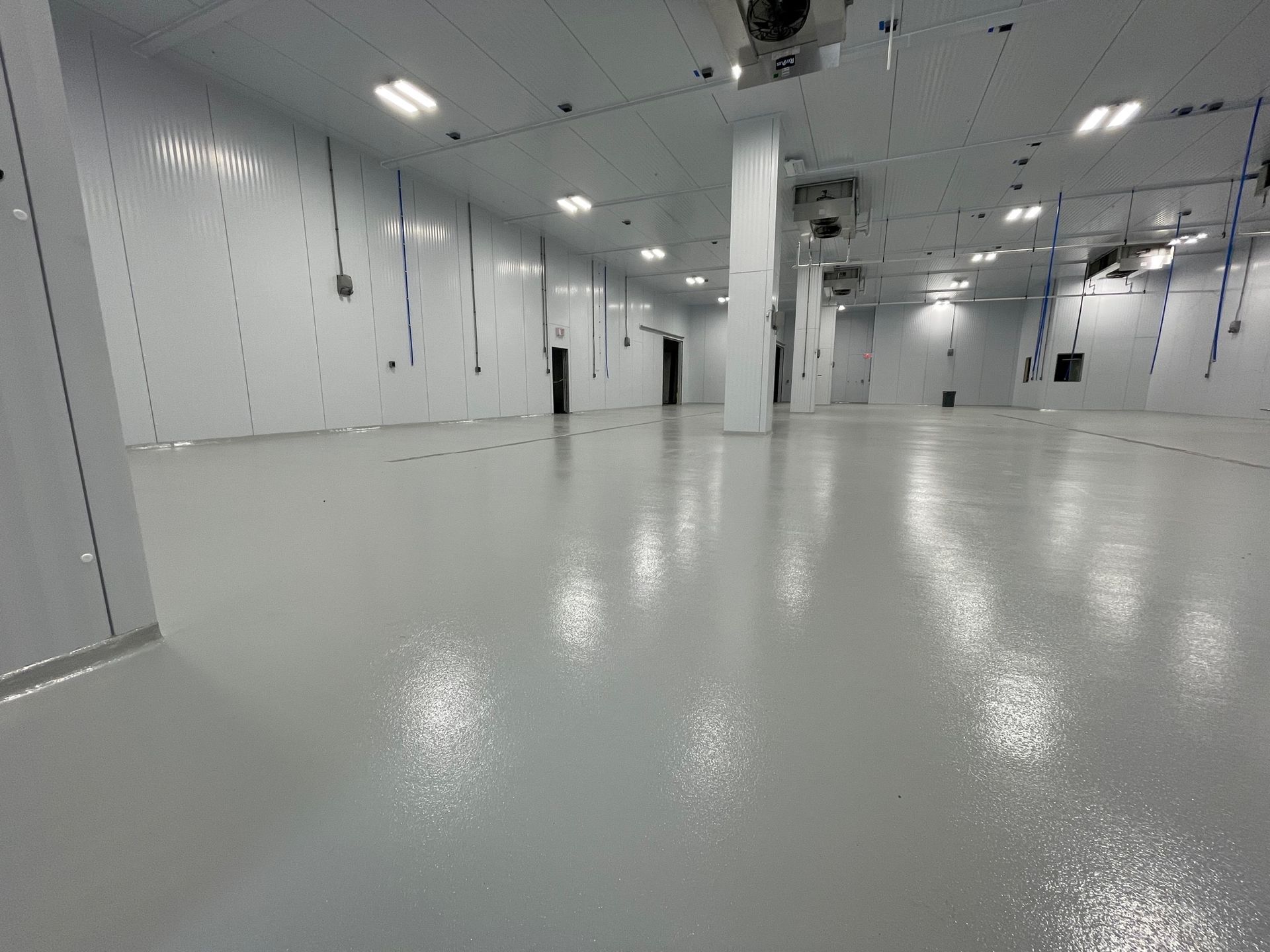 A large warehouse with a white floor and white walls.