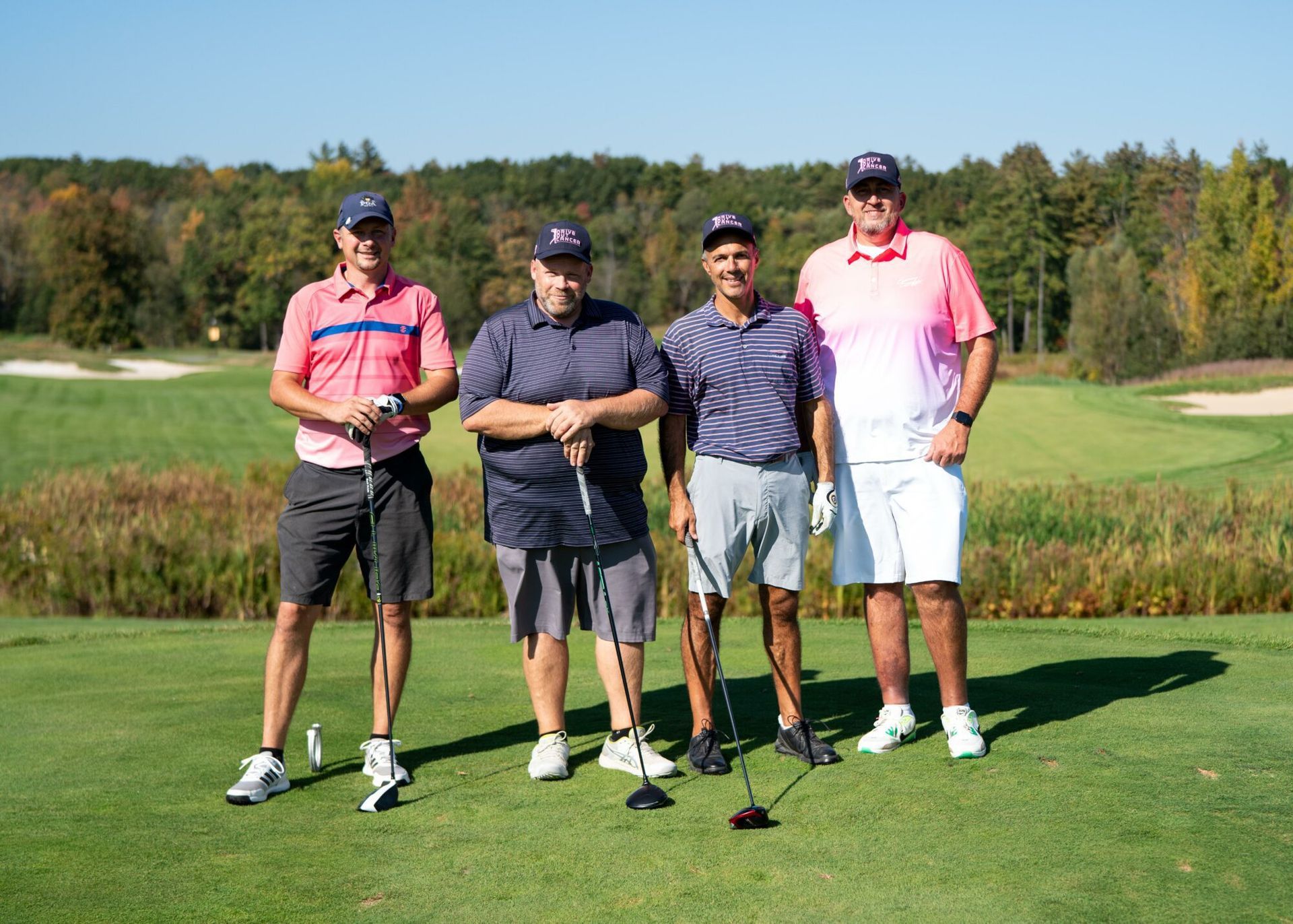 A group of men are posing for a picture on a golf course.