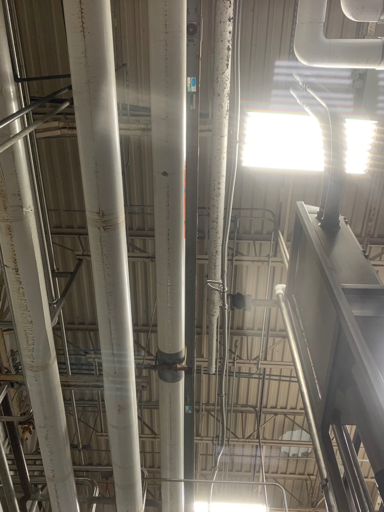 A Bunch of Pipes Are Hanging from The Ceiling of A Building | S. Glens Falls, NY | Performance Industrial