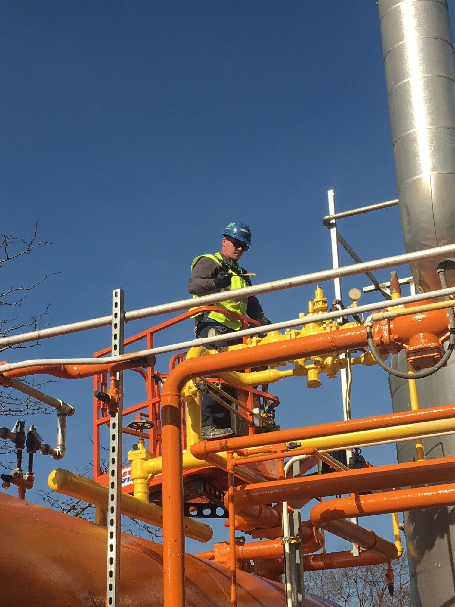 A man in a hard hat is working on a pipe