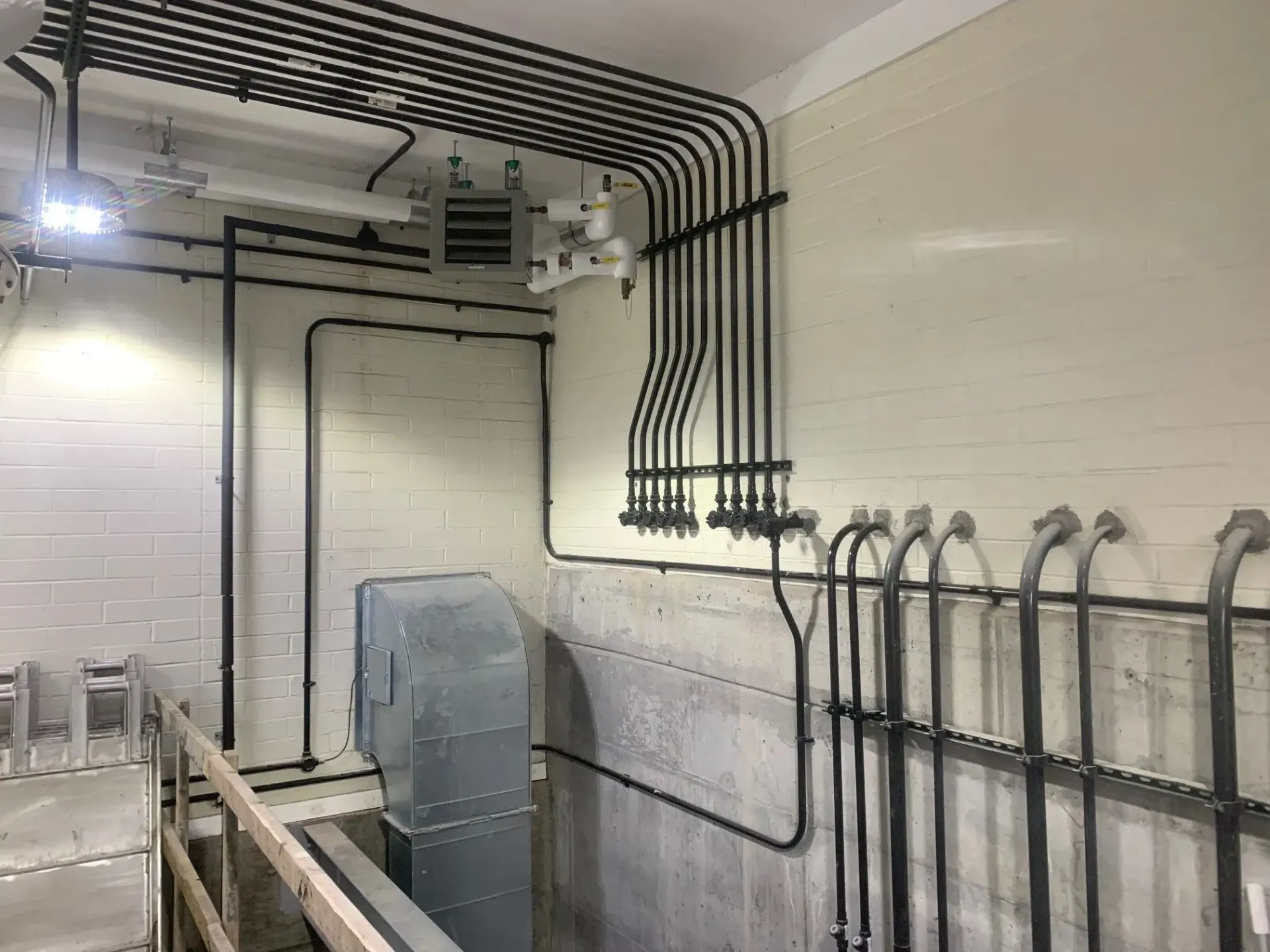 A room with a lot of pipes hanging from the ceiling.