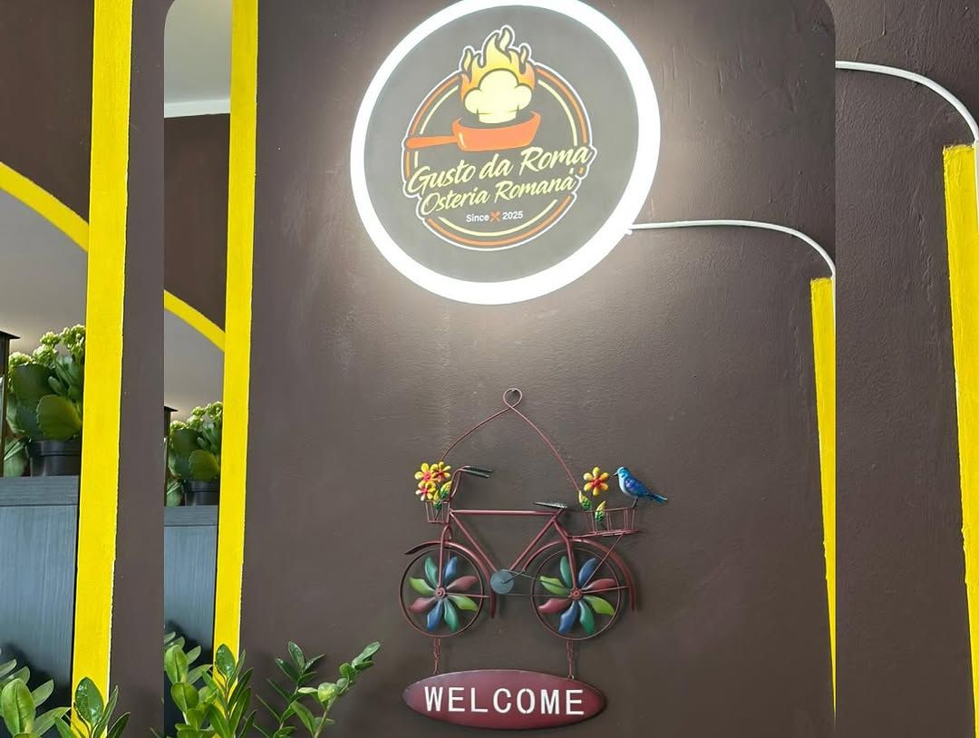 Insegna con il logo del ristorante e decorazione a forma di bicicletta con la scritta 