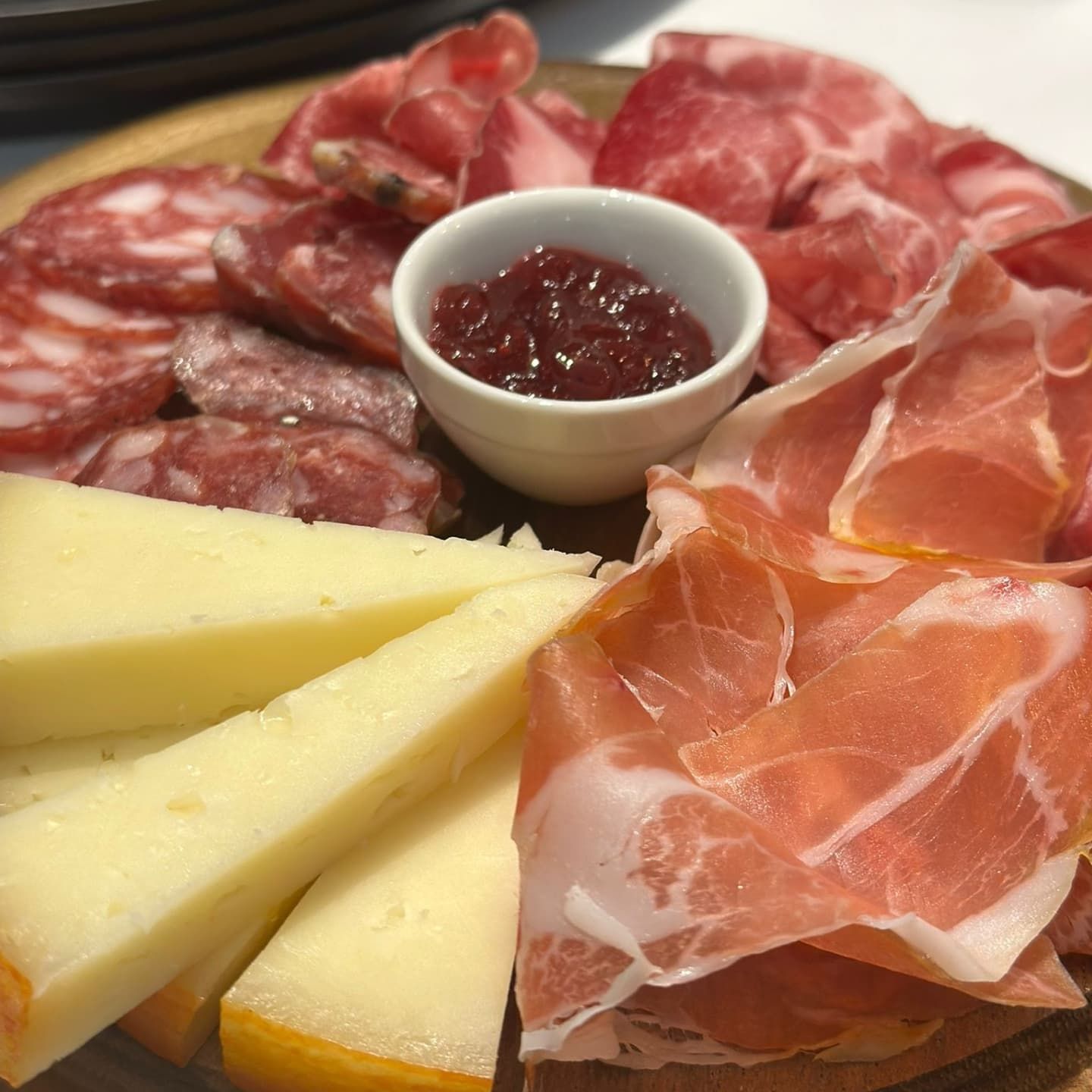 Tagliere di salumi con affettati, formaggi e marmellata.