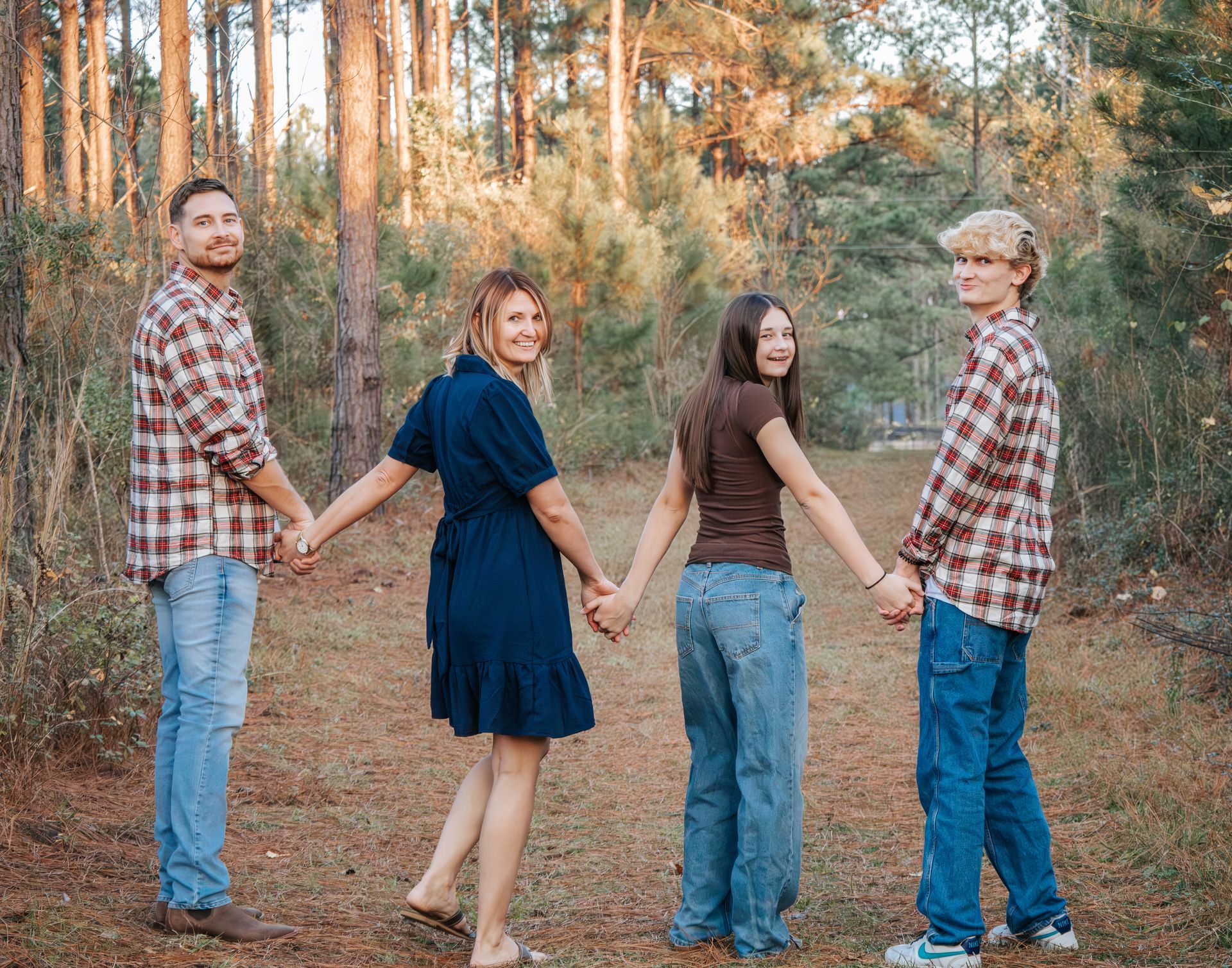 A family is playing in the grass in front of their house.