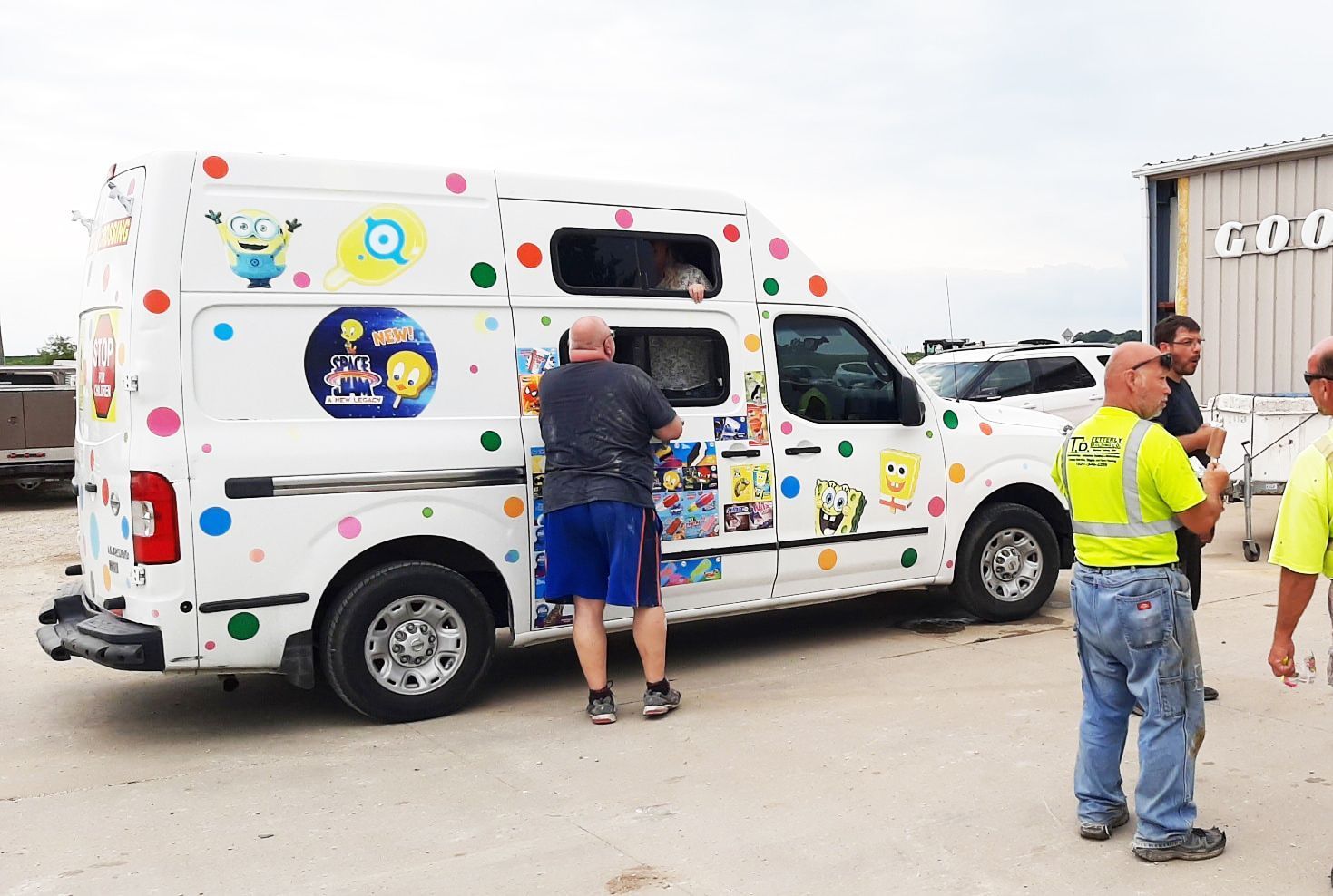 A group of men are standing around an ice cream truck.