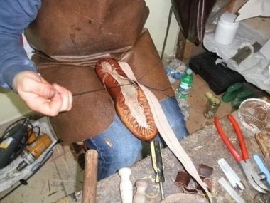artigiano durante la riparazione della suola di una scarpa
