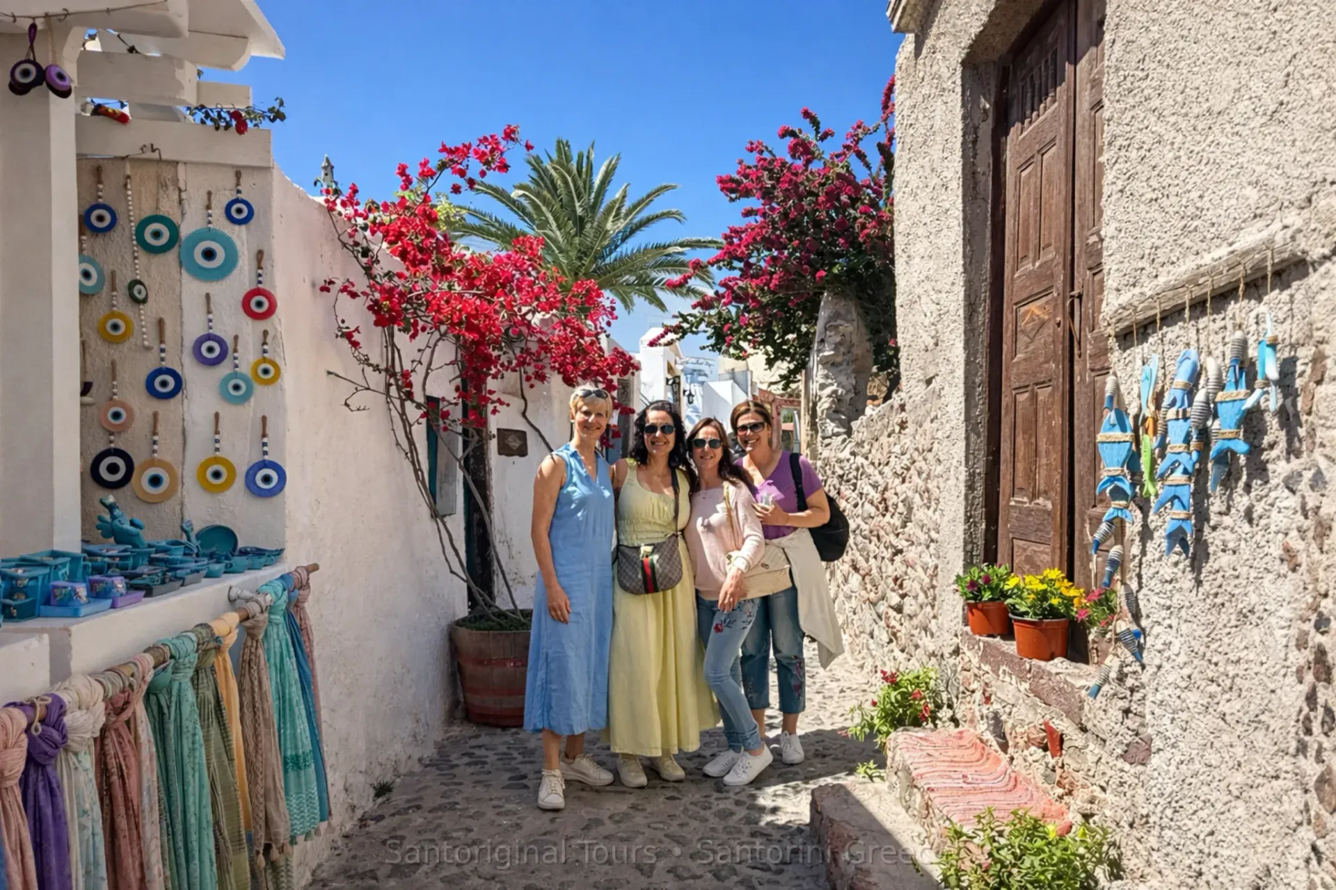 Friends walking in a colorful alley in Oia, Santorini