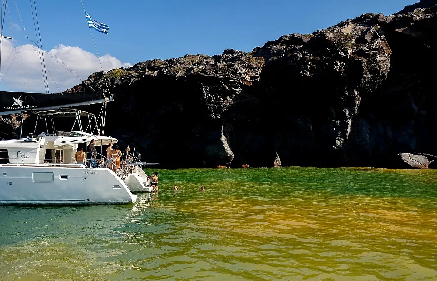 Swimming near Santorini’s hot springs during a private catamaran cruise