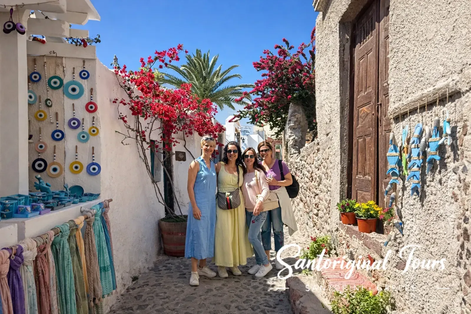 Friends walking in a colorful alley in Oia, Santorini