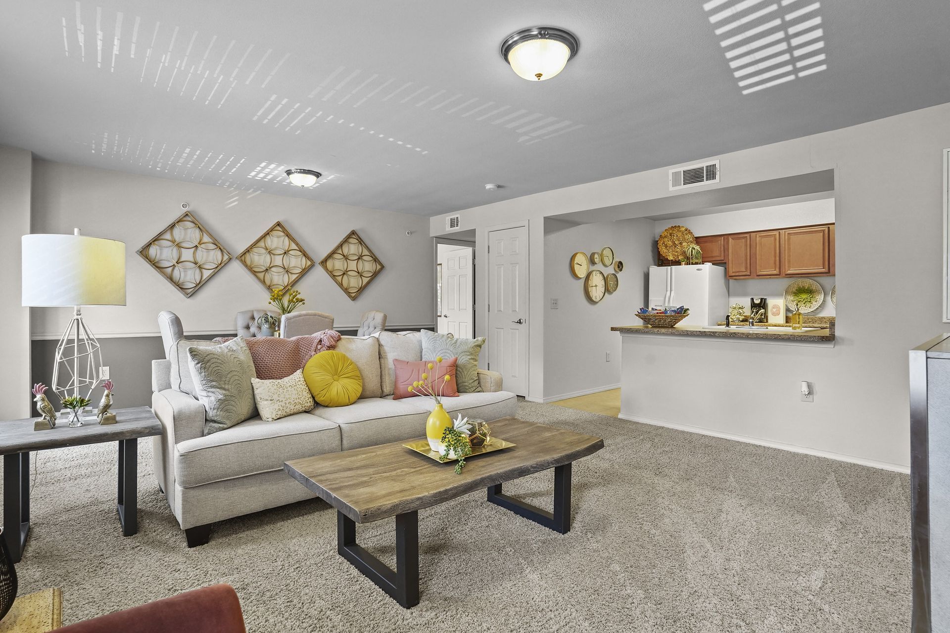 Living room with beige couch, wooden coffee table, and open kitchen.