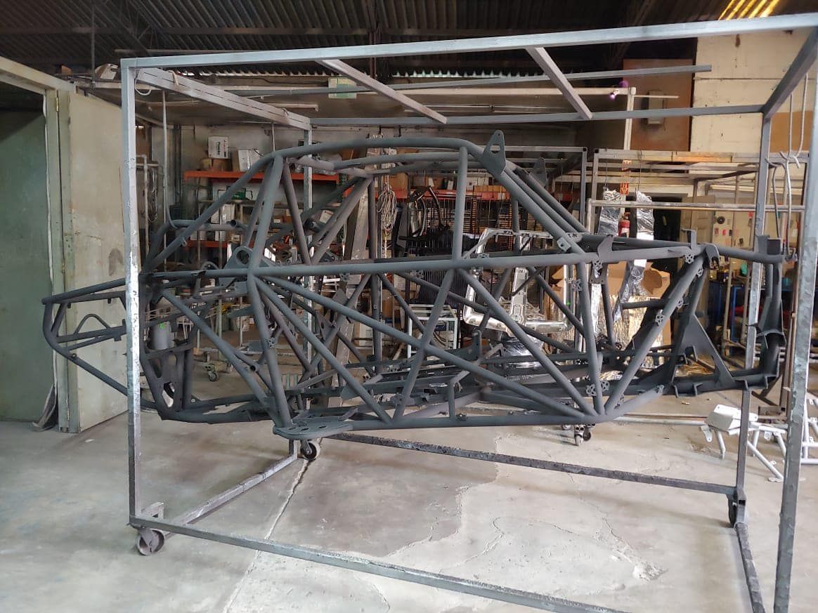 Una estructura de metal está colocada sobre un carro en un garaje.