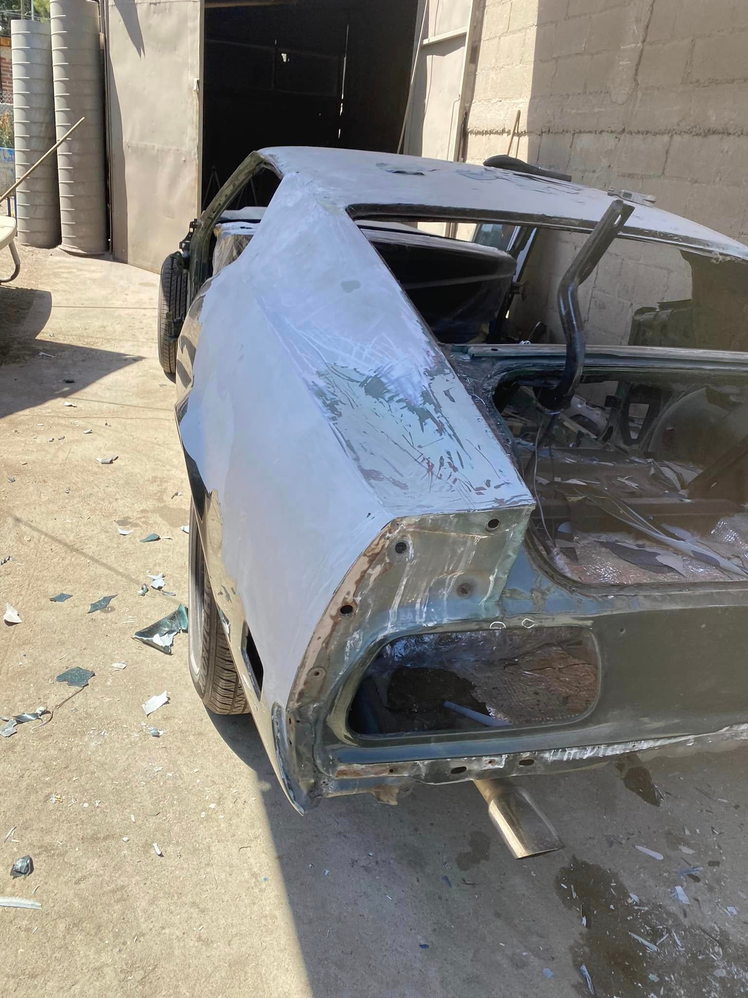 Un auto blanco está parado en el suelo frente a un edificio.