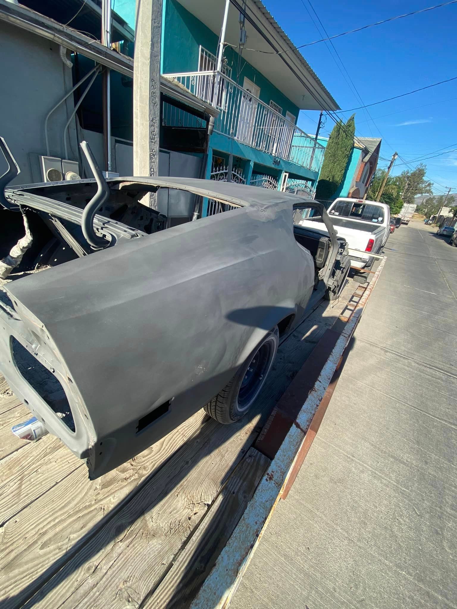 Un automóvil está estacionado al costado de la carretera al lado de un edificio.