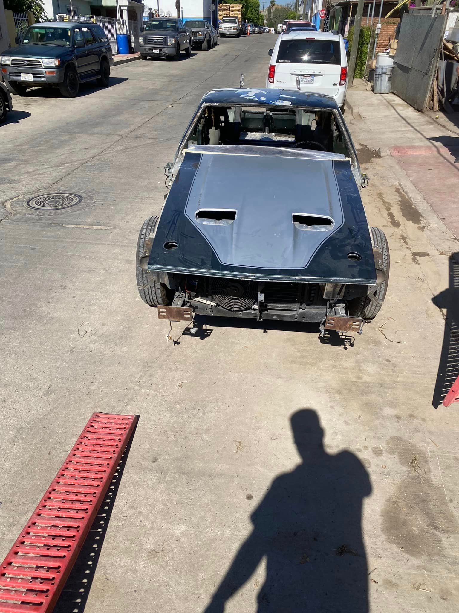 Un auto negro está estacionado al costado de la carretera junto a una rampa roja.