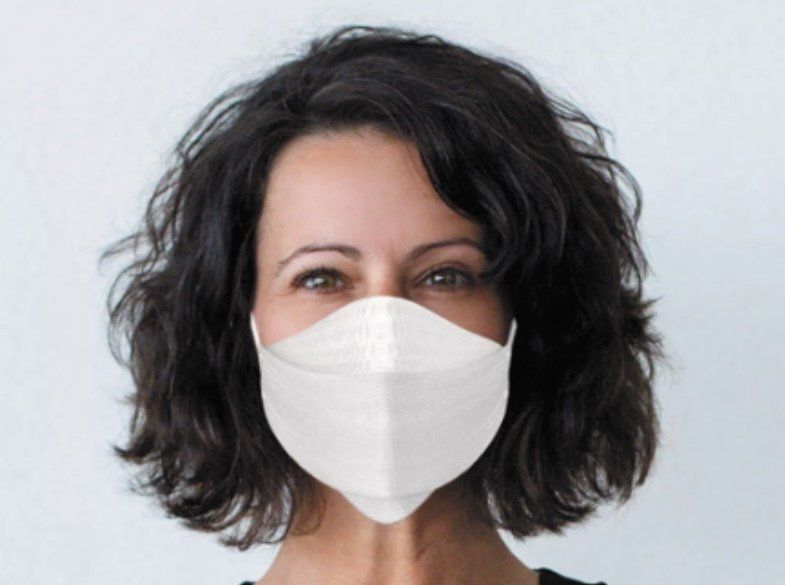 A woman wearing a white face mask on her face