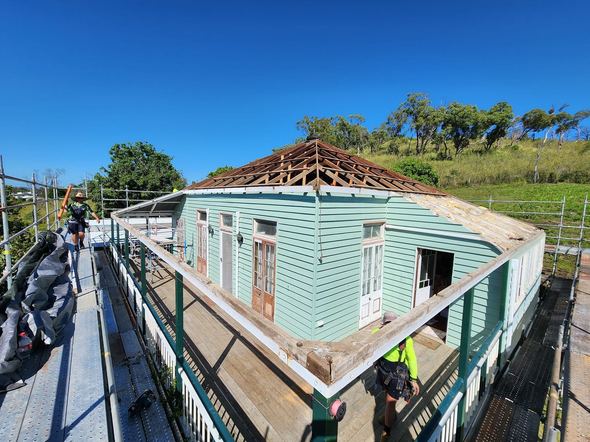 A Pale Green Wooden House Undergoing Roof Renovations — Rhettro Roofing Industry in Taroomball, QLD