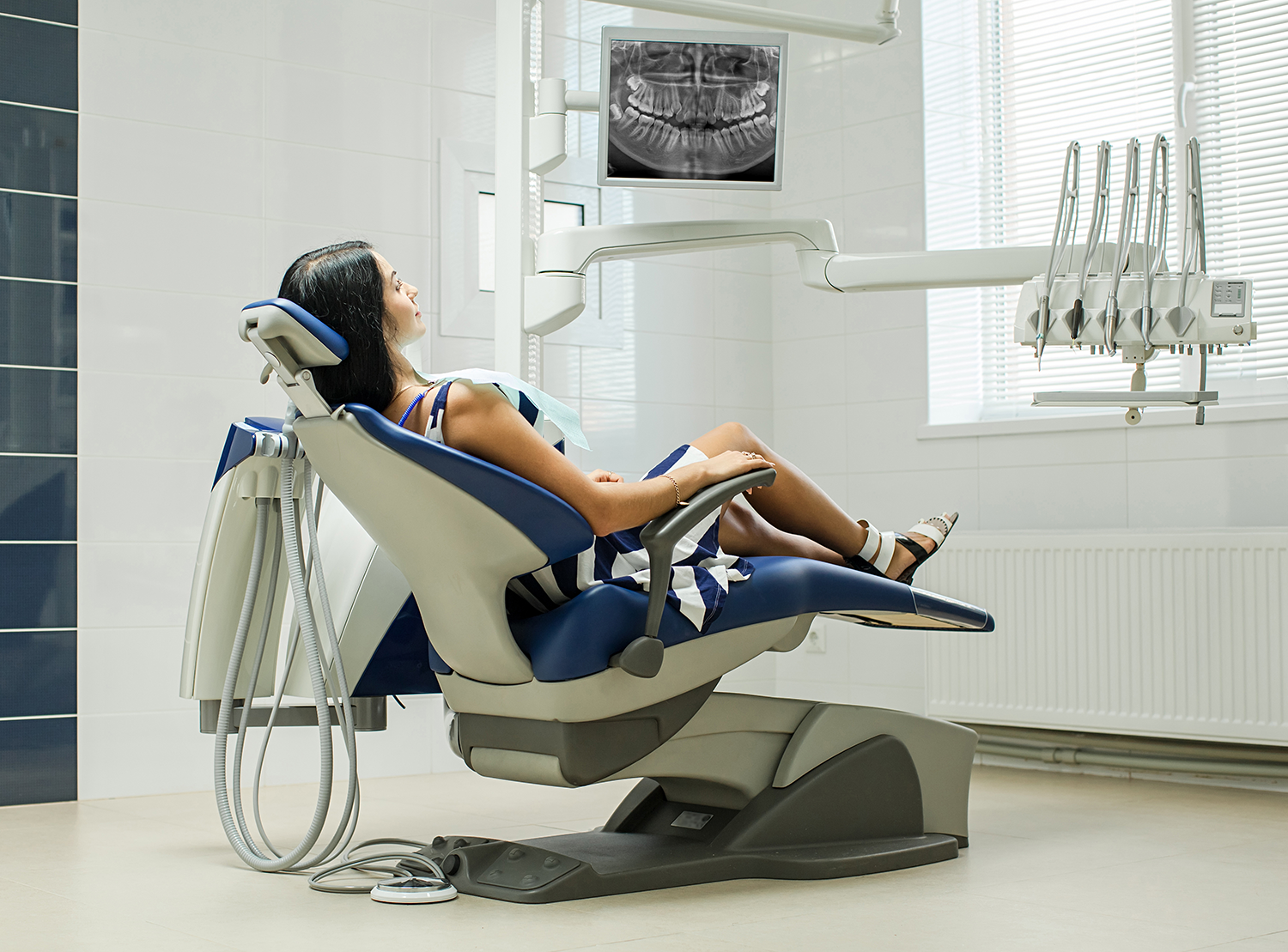 a woman is laying in a dental chair in a dental office.