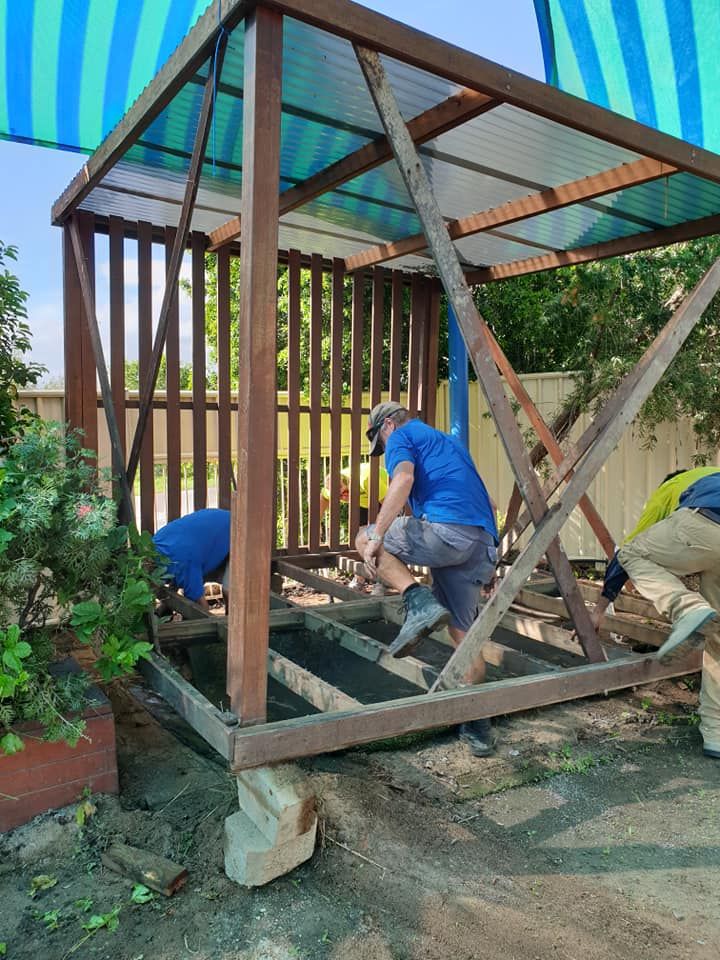 A Group of Men Are Working on A Wooden Structure — Port O' Call Cleaning In Bowen, QLD