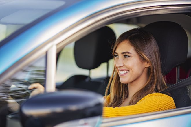 Girl smiling behind the wheel — Clearwater, FL — Nichols & Dimes Rent A Car Inc