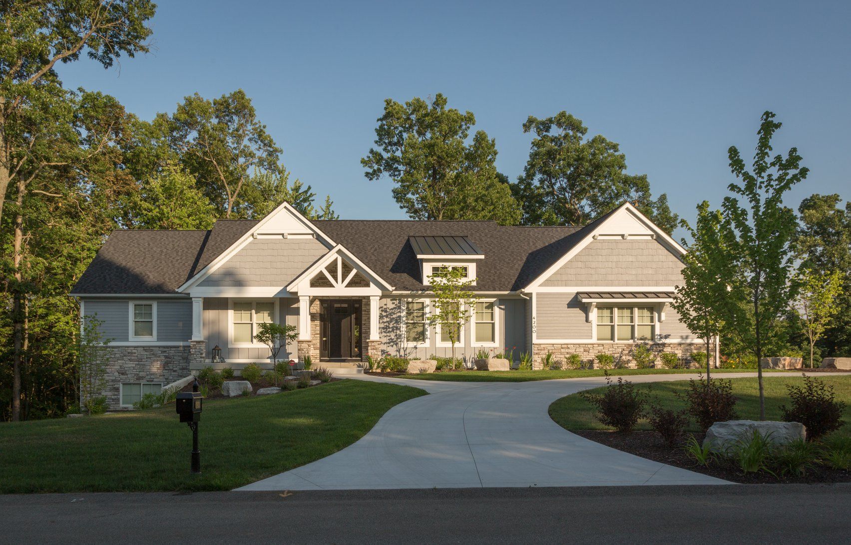 A large house with a driveway and a mailbox in front of it.