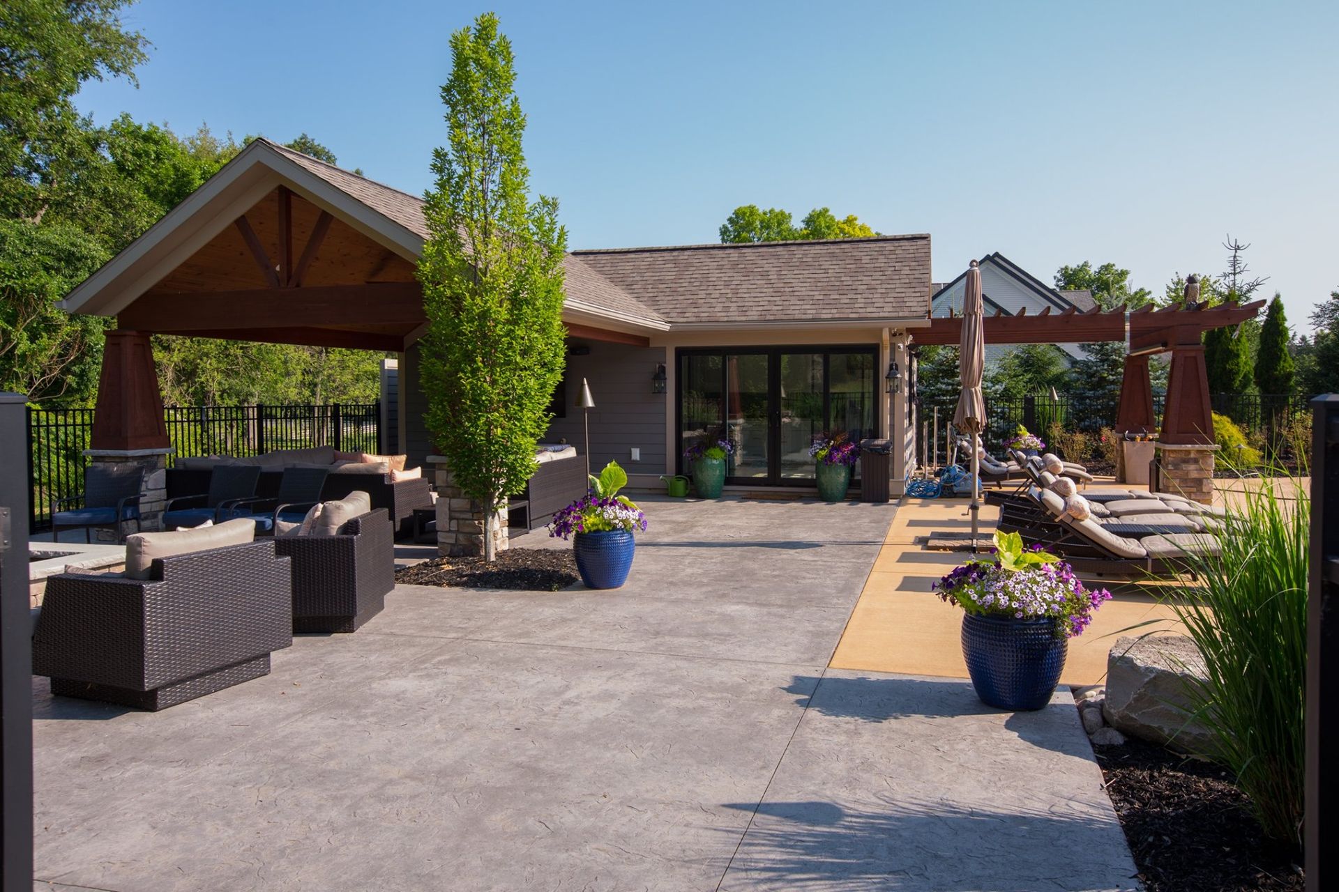 A patio area with a gazebo and chairs in front of a house.