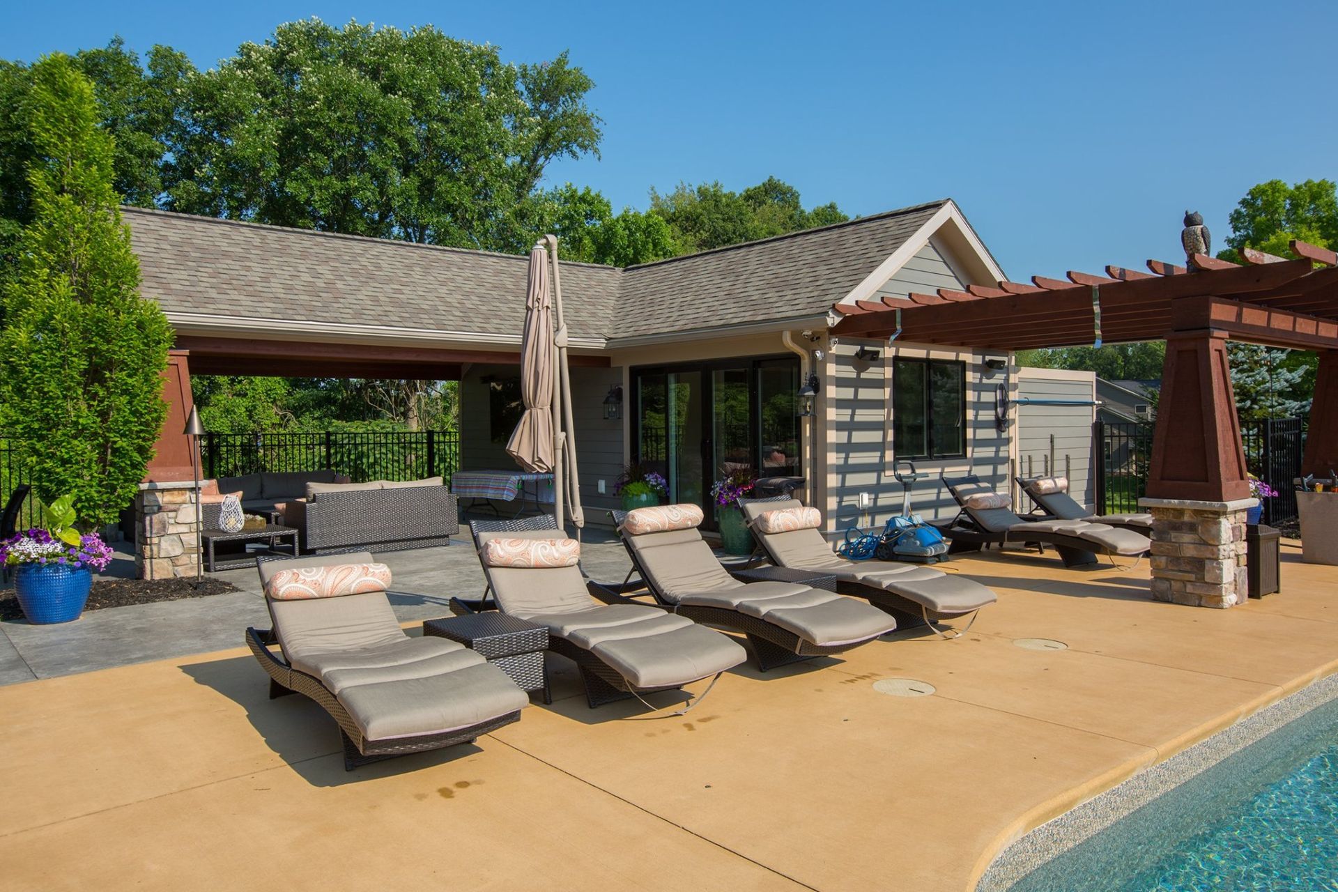 A row of lounge chairs are lined up next to a swimming pool.