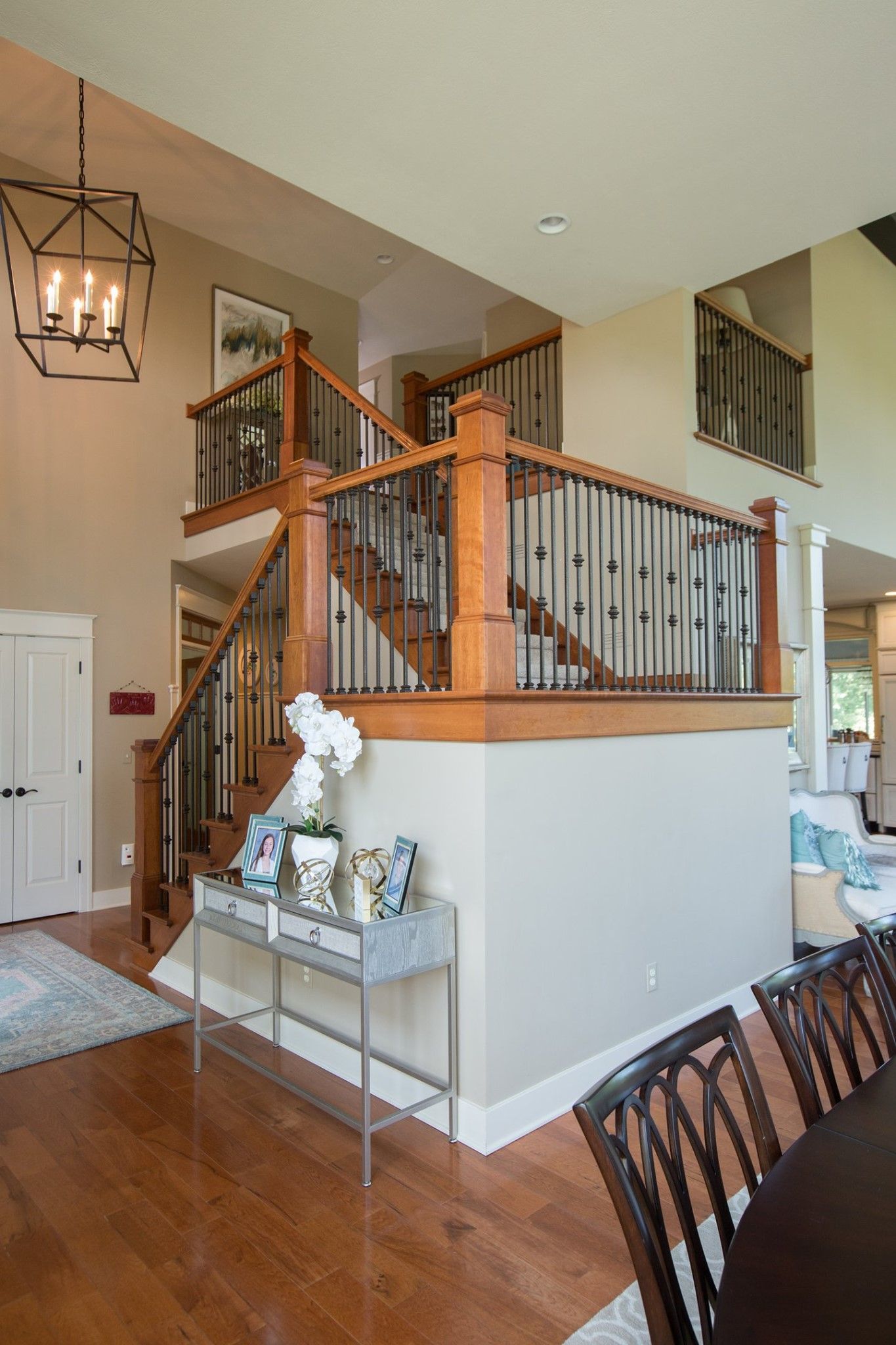 A living room with a table and chairs and a staircase leading to the second floor.