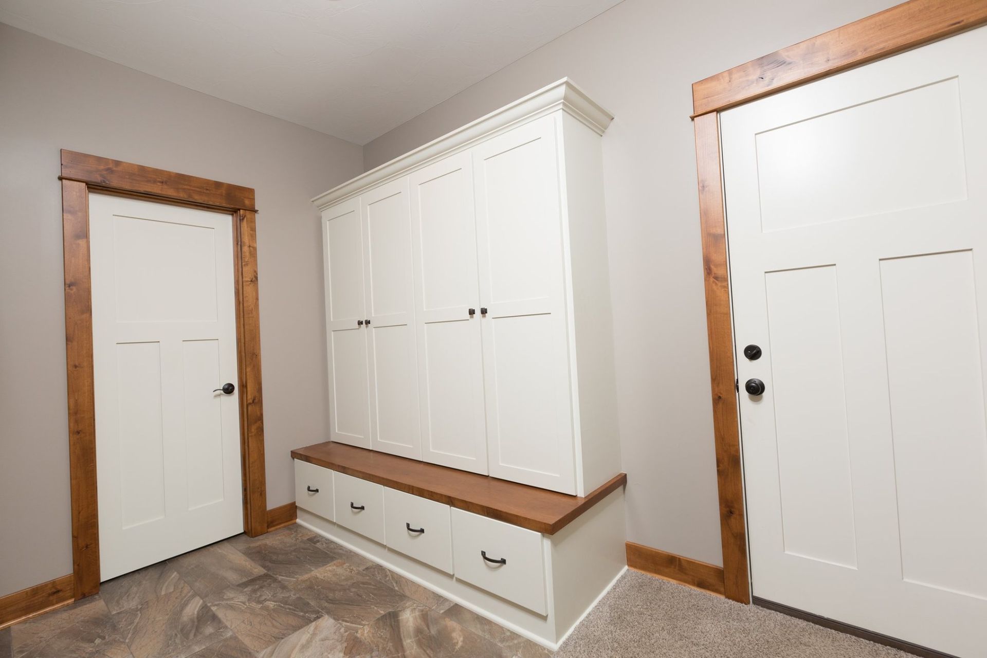 A room with white cabinets and wooden doors.