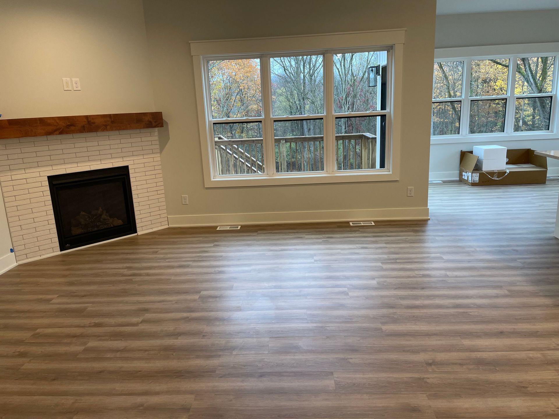 An empty living room with a fireplace and lots of windows.