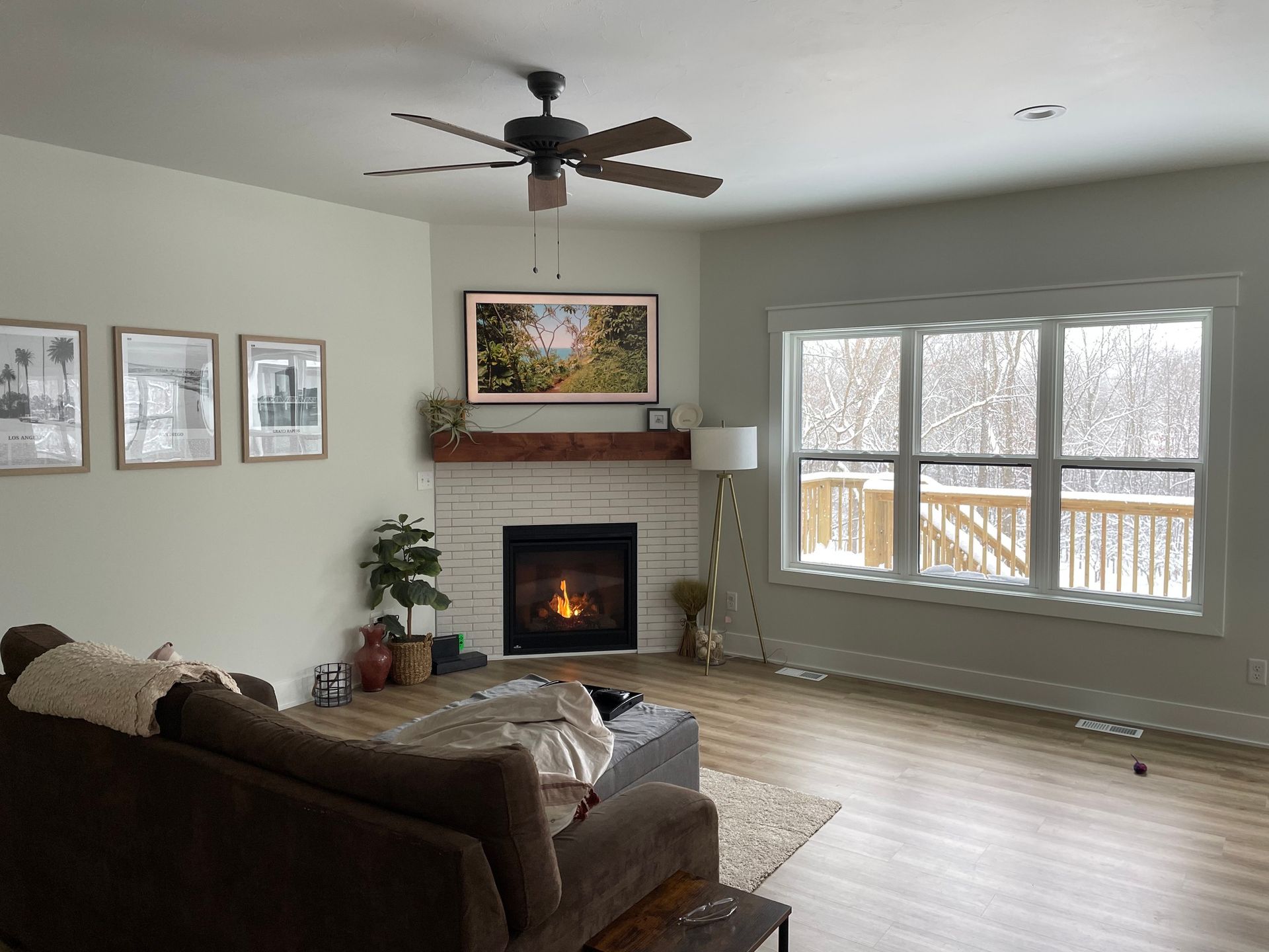 A living room with a fireplace and a ceiling fan.